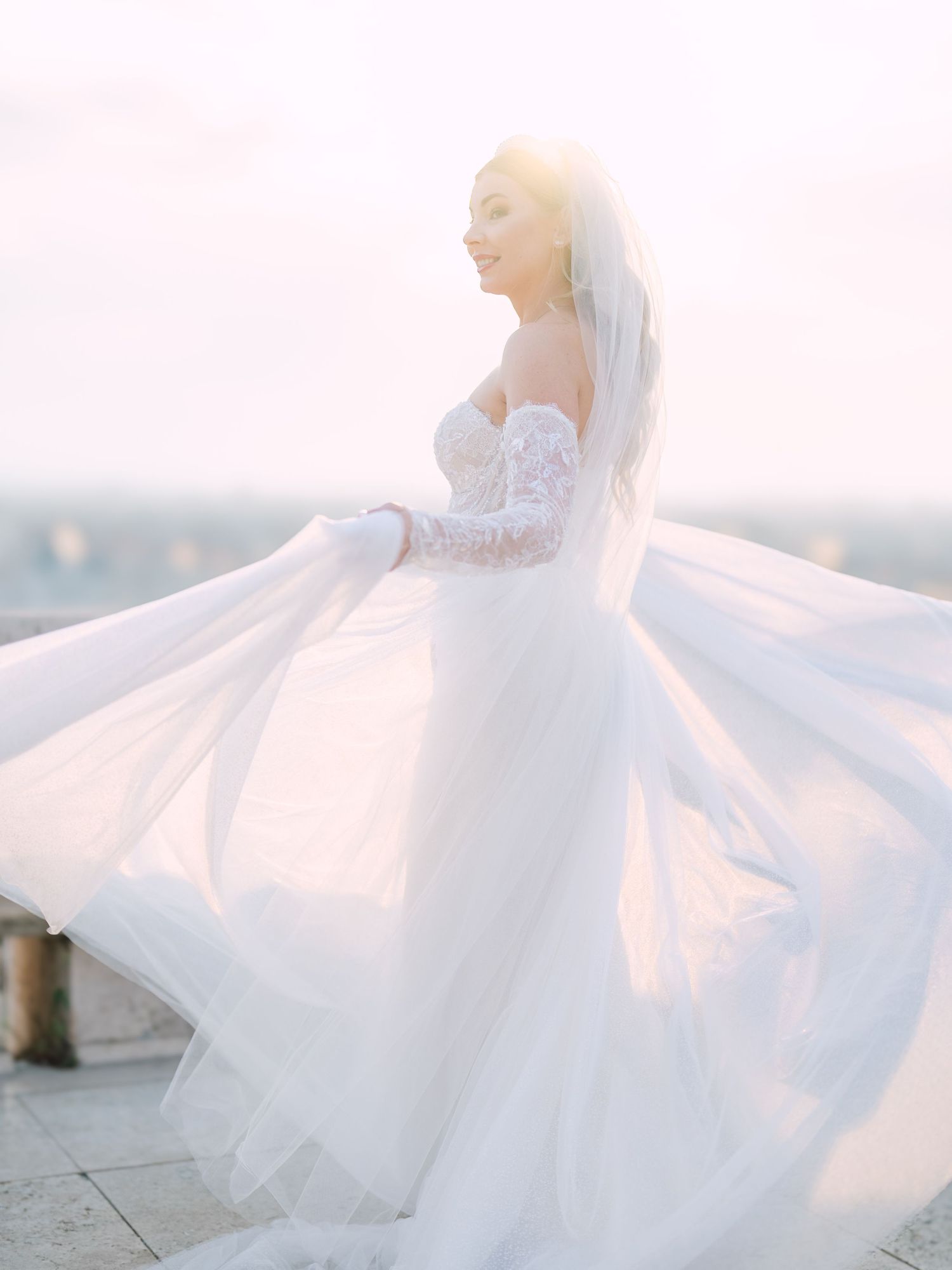 Elegant bride posing gracefully in a La Mariée dress at sunrise on Fisherman’s Bastion in Budapest, captured by Hang Pham Photography