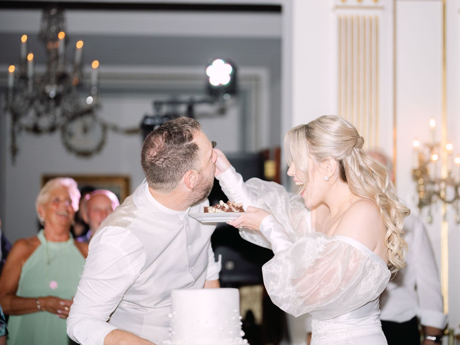 Wedding couple cutting and tasting their cake at Gundel Restaurant during an intimate luxury destination wedding celebration in Budapest