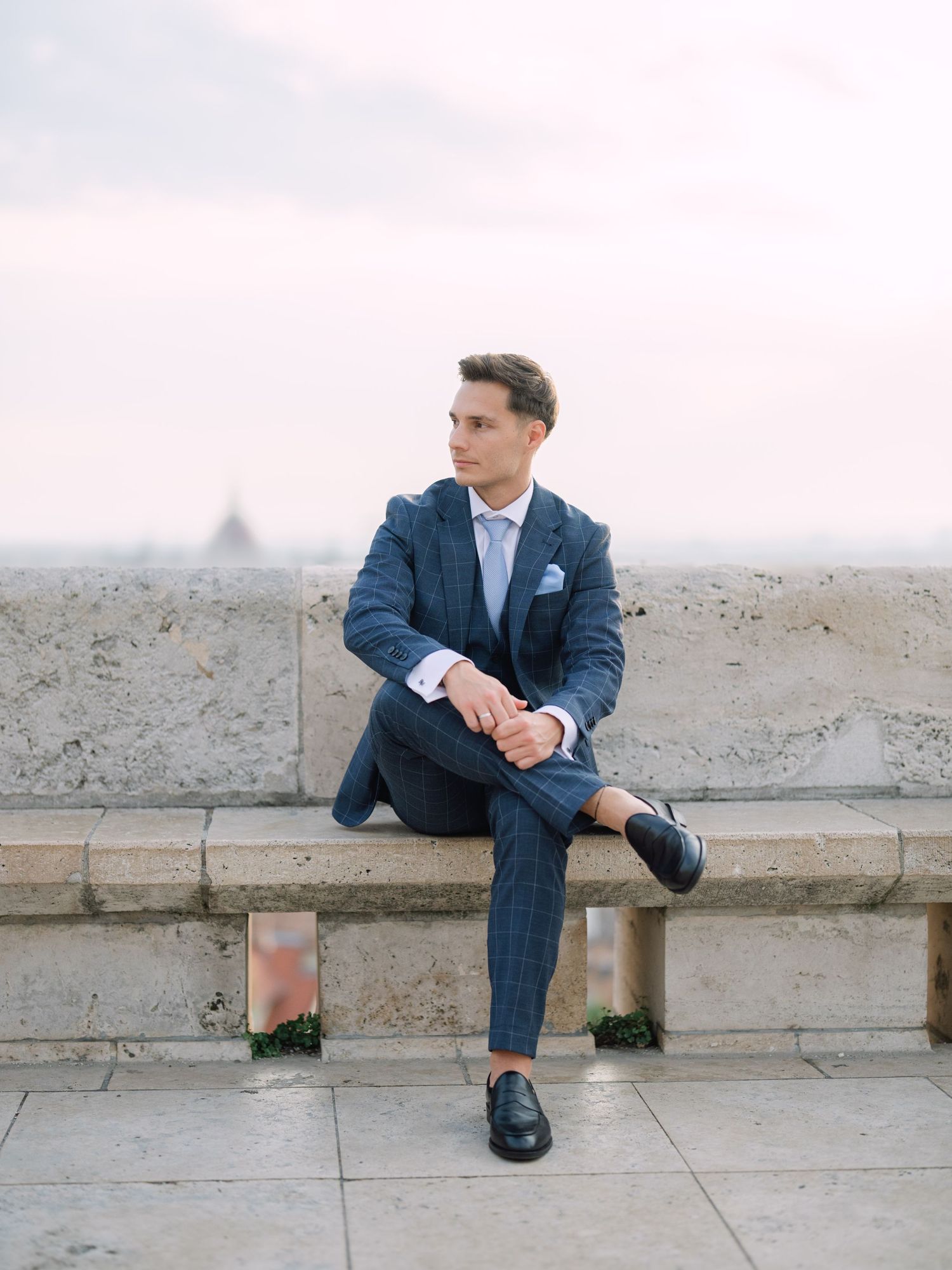 Captivating groom posing at sunrise on Fisherman’s Bastion in Budapest during a romantic pre-wedding session, captured by Hang Pham