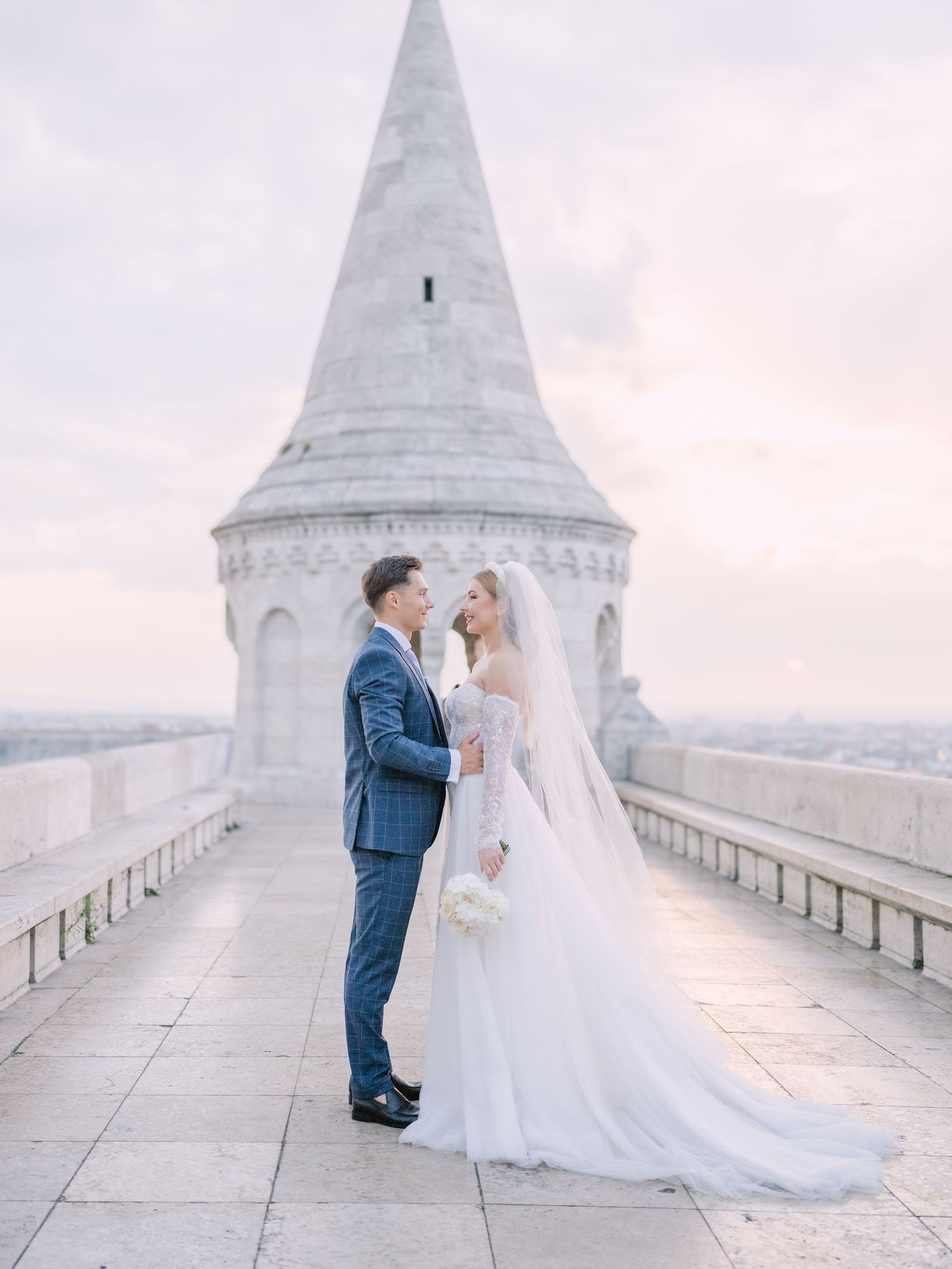 Captivating couple posing at sunrise on Fisherman’s Bastion in Budapest for a pre-wedding session, captured by Hang Pham Photography