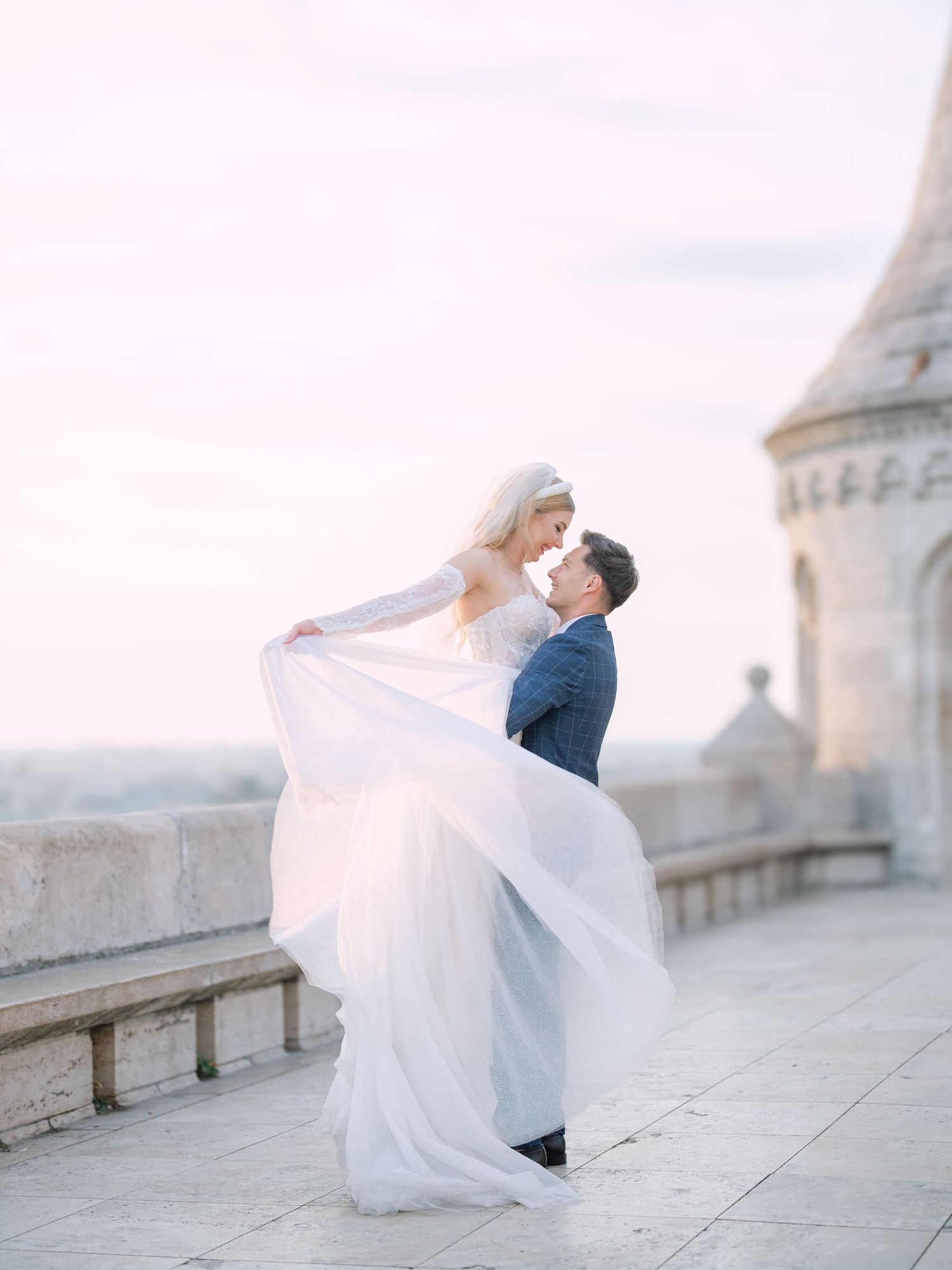 Captivating couple posing at sunrise on Fisherman’s Bastion in Budapest for a pre-wedding session, captured by Hang Pham Photography