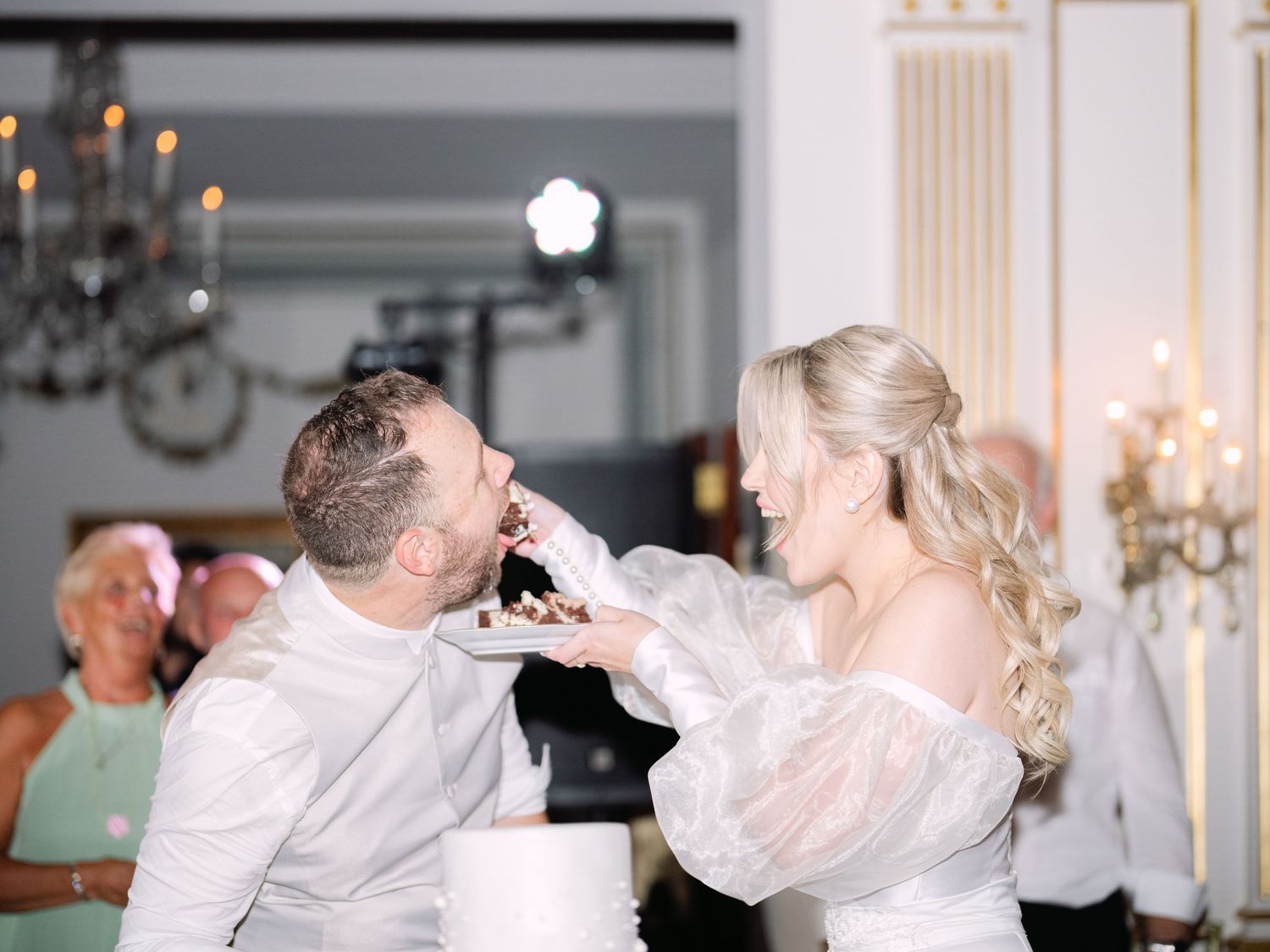 Wedding couple cutting and tasting their cake at Gundel Restaurant during an intimate luxury destination wedding celebration in Budapest