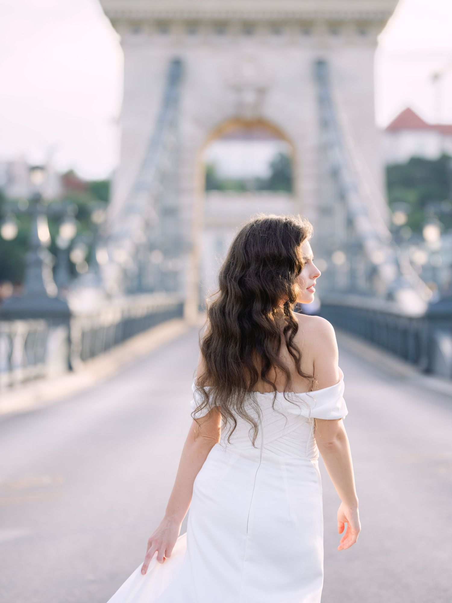 Captivating bride in a Leya Couture dress posing on Chain Bridge in Budapest during a destination wedding editorial by Hang Pham Photography