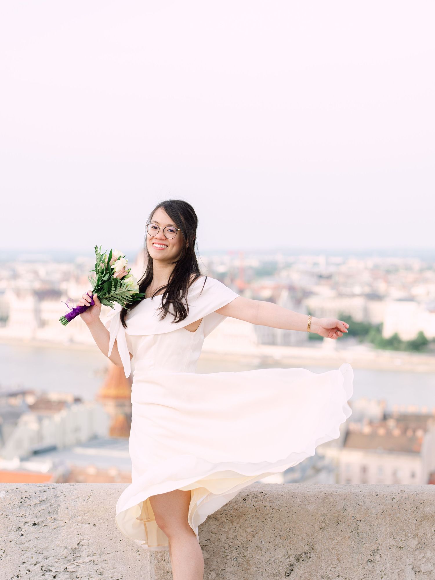 Charming bride posing during a scenic engagement shoot with breathtaking views of Budapest from Fisherman’s Bastion at golden hour