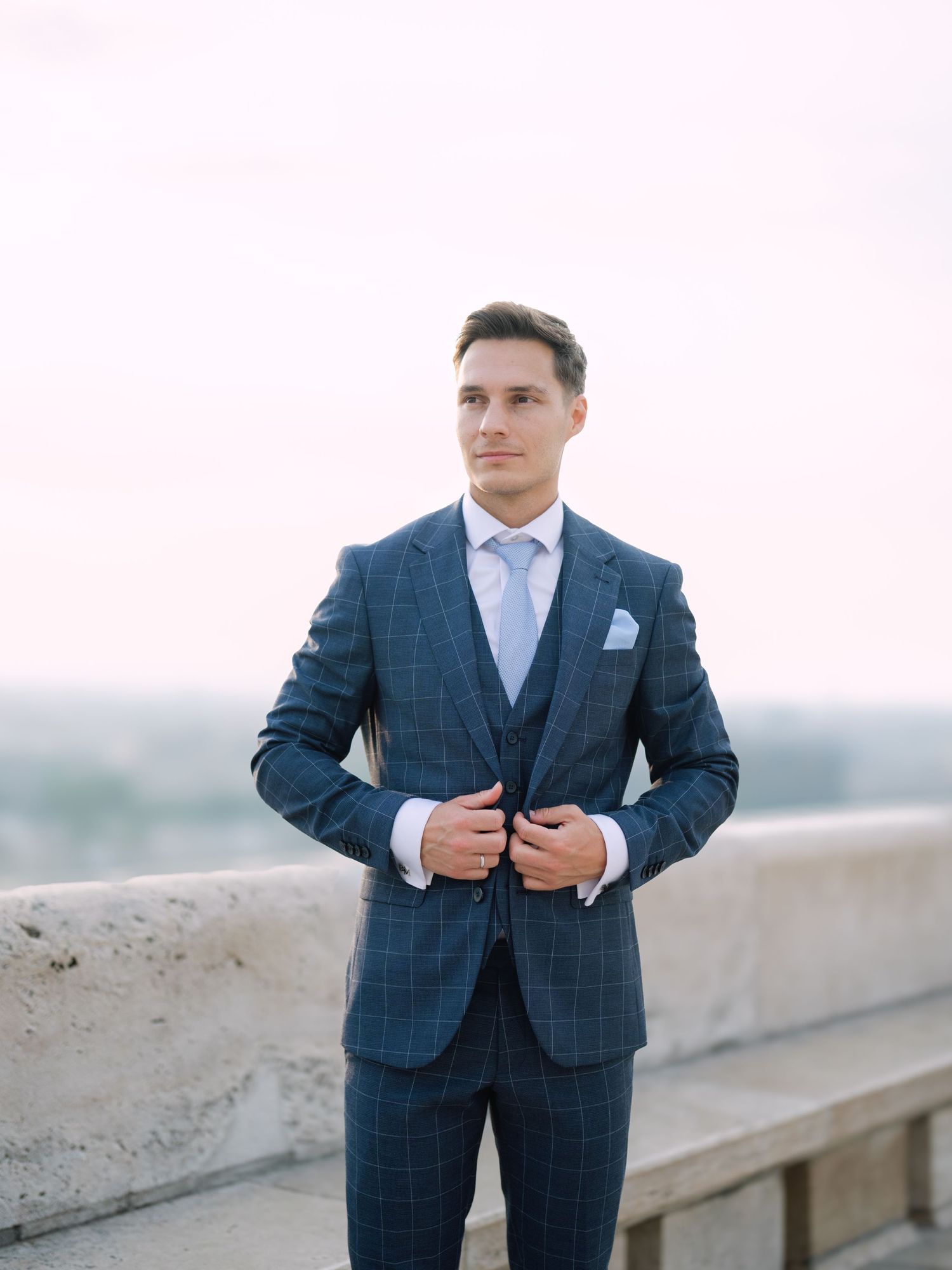 Captivating groom posing at sunrise on Fisherman’s Bastion in Budapest during a romantic pre-wedding session, captured by Hang Pham