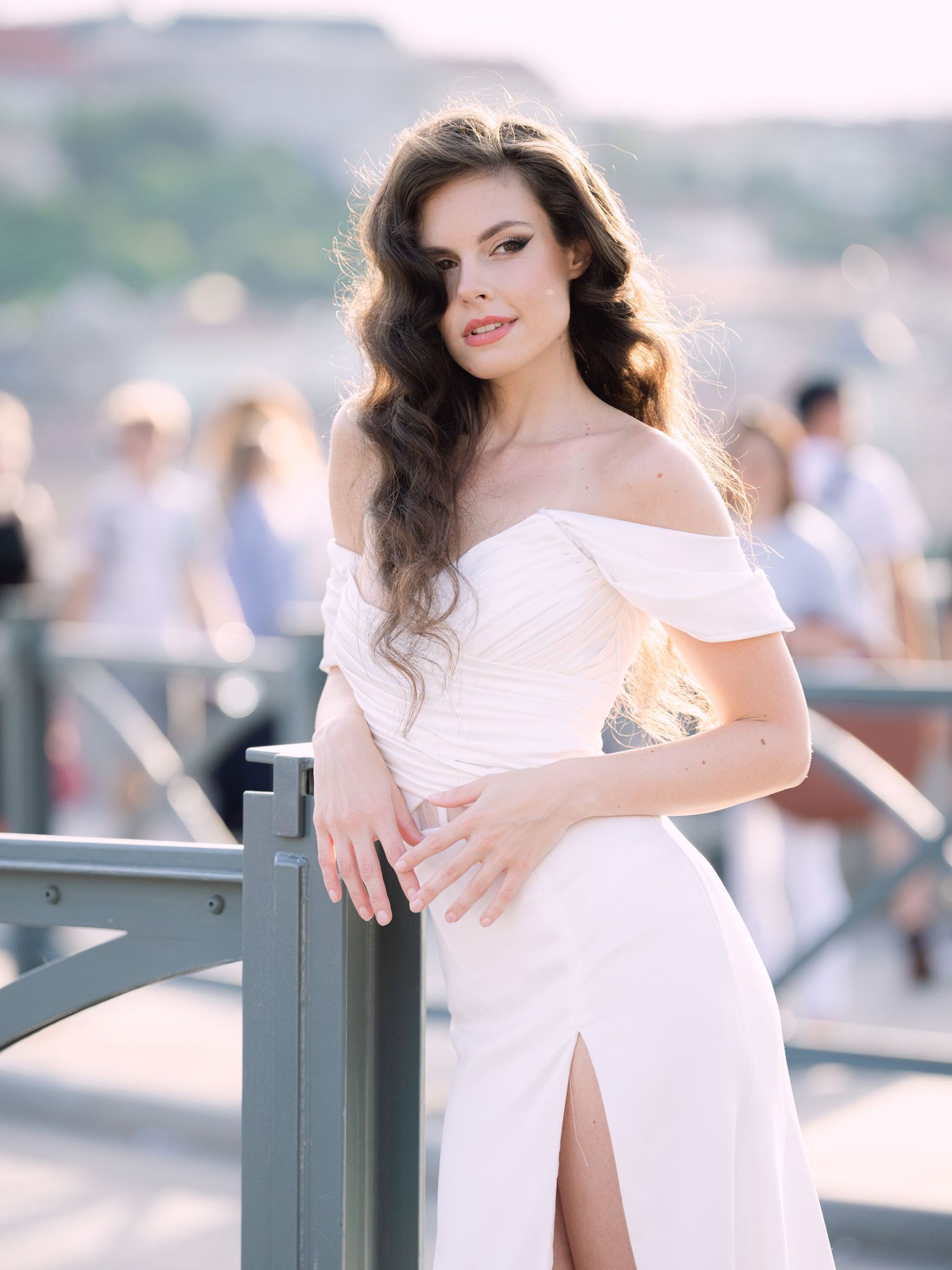 Elegant bride in a Leya Couture wedding dress posing on Budapest’s iconic Chain Bridge during a golden hour destination wedding editorial