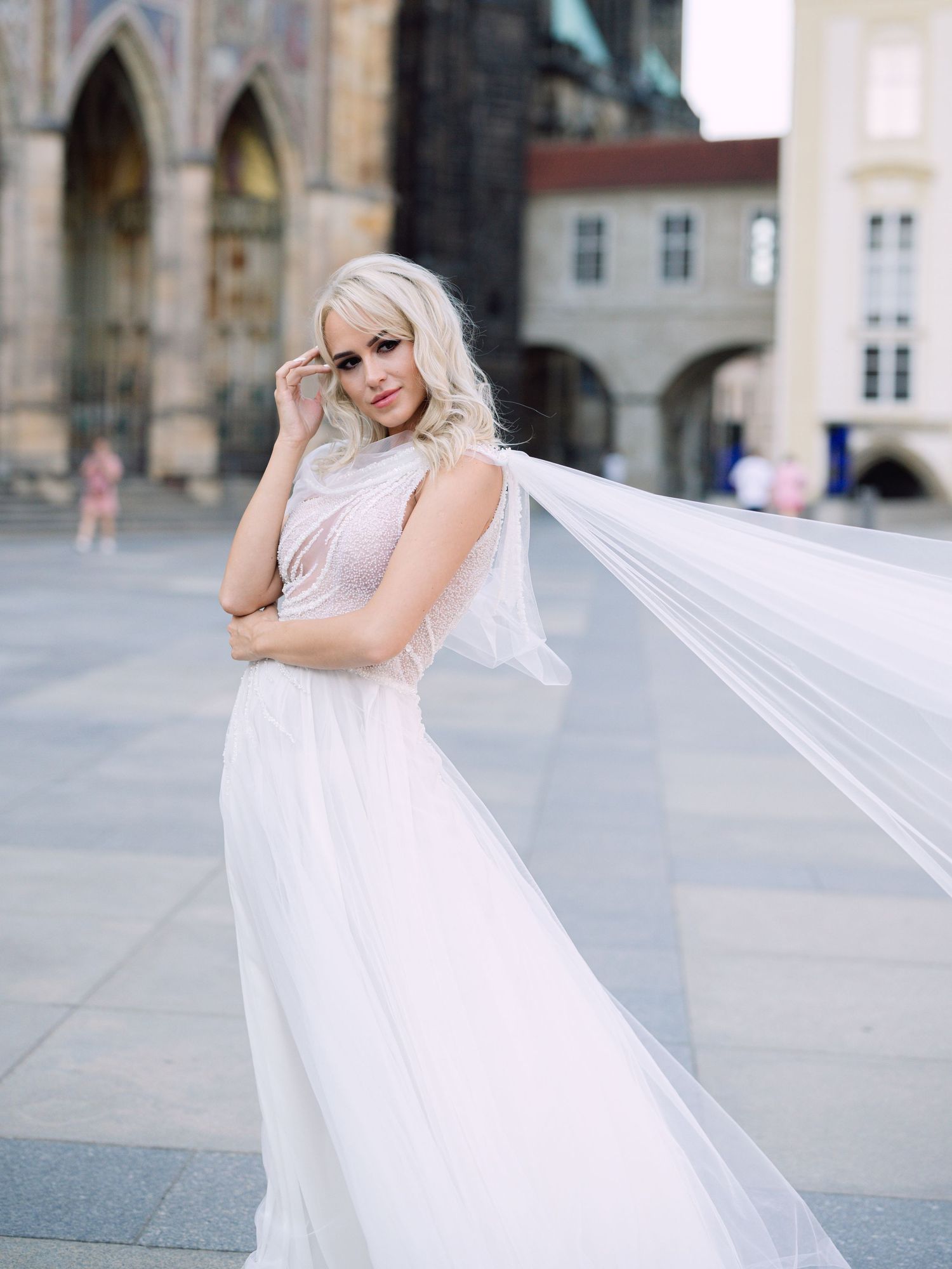 Dynamic bride in a Kozarics Viktor dress posing at Prague Castle for a destination wedding, beautifully captured by Hang Pham Photography