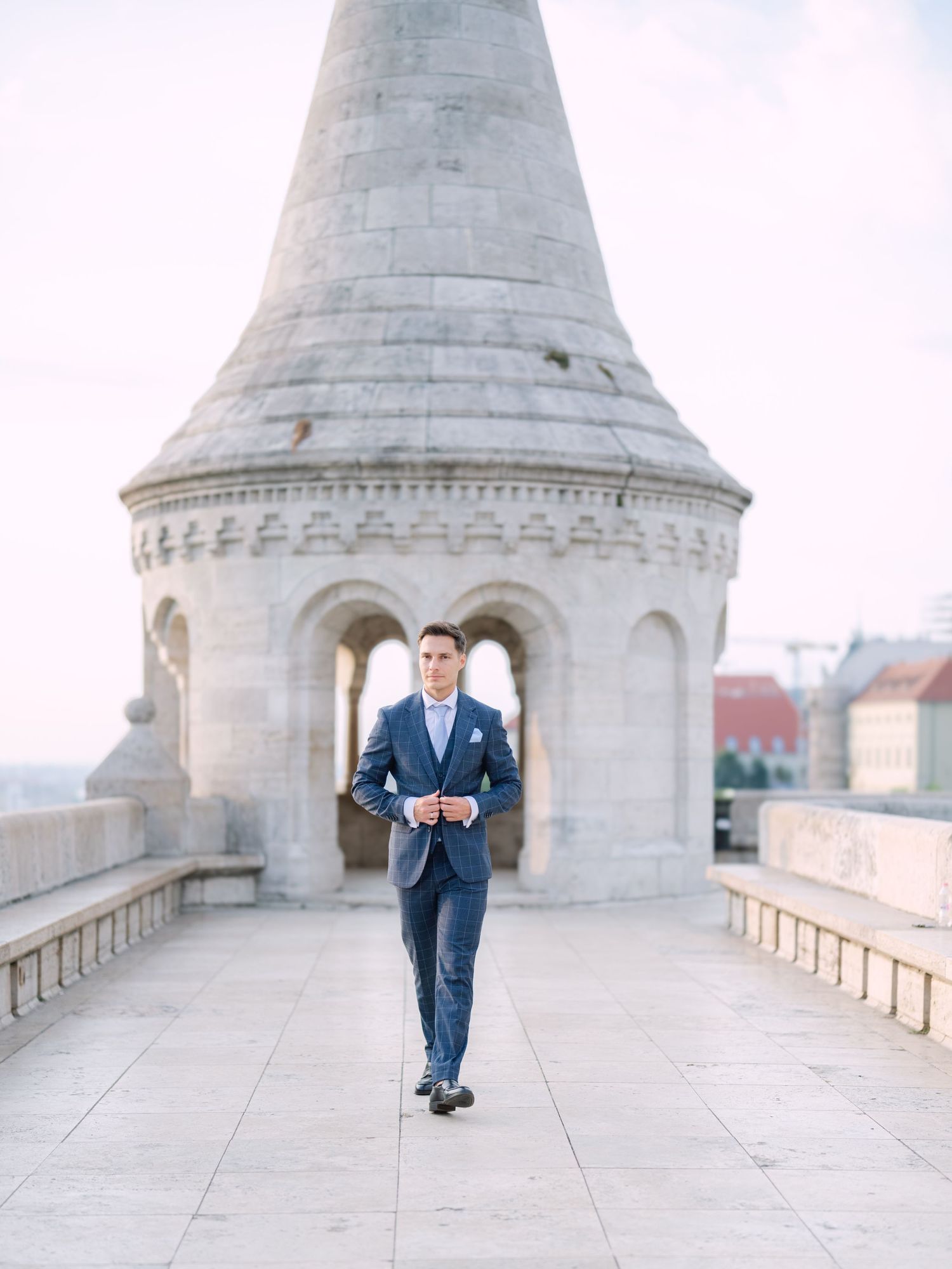 Captivating groom posing at sunrise on Fisherman’s Bastion in Budapest during a romantic pre-wedding session, captured by Hang Pham