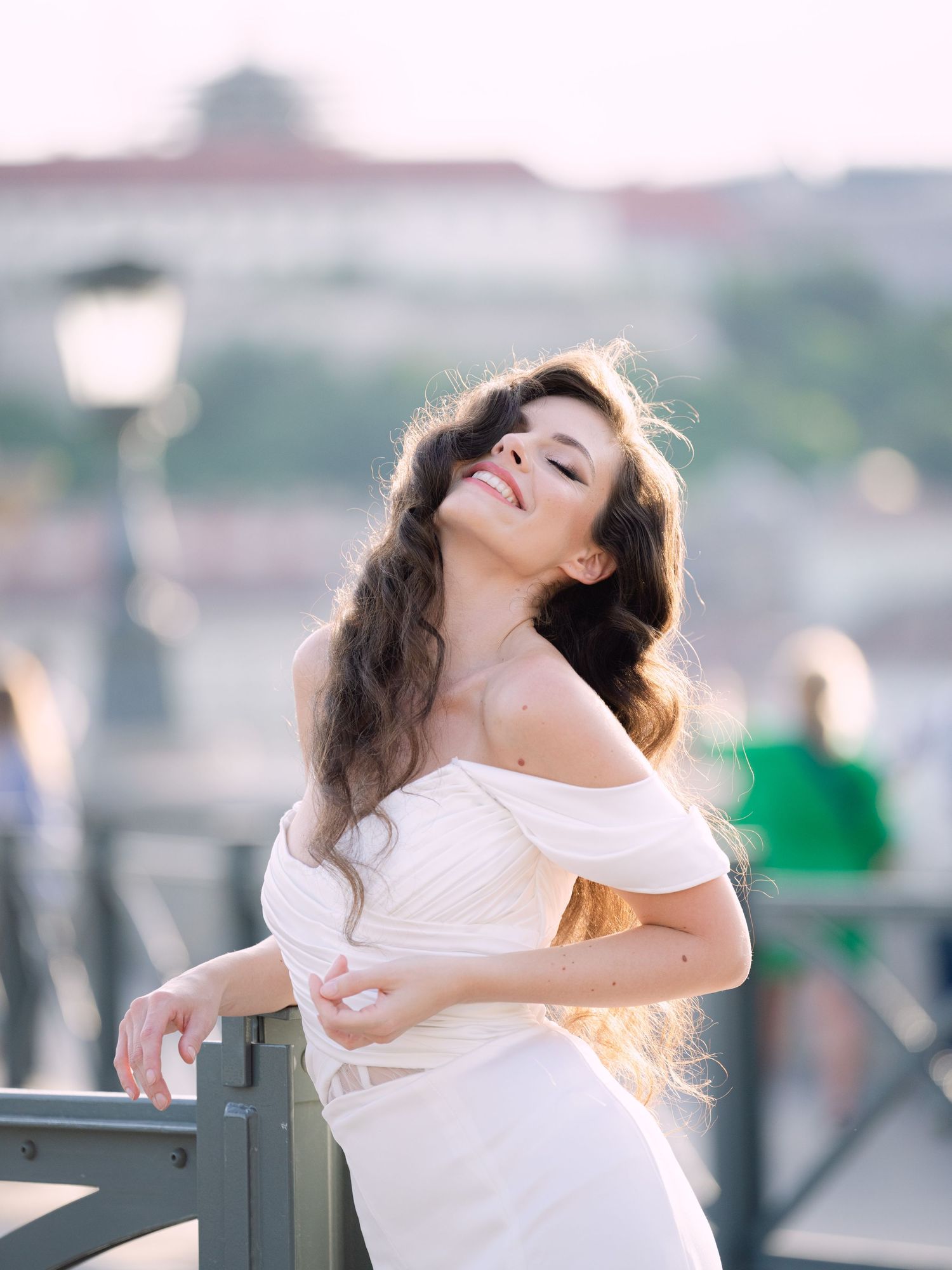 Elegant bride in a Leya Couture wedding dress posing on Budapest’s iconic Chain Bridge during a golden hour destination wedding editorial