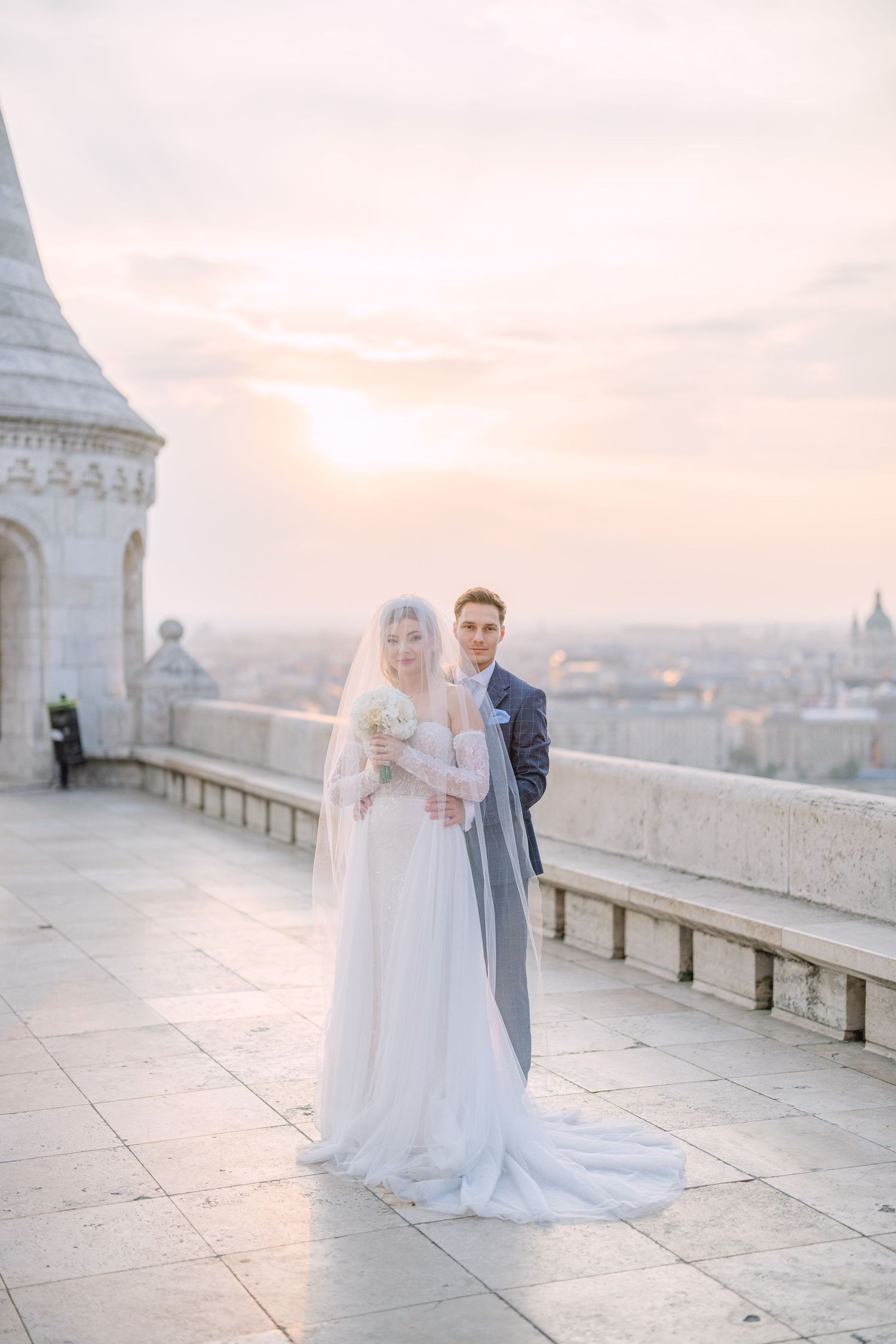 Captivating couple posing at sunrise on Fisherman’s Bastion in Budapest for a pre-wedding session, captured by Hang Pham Photography