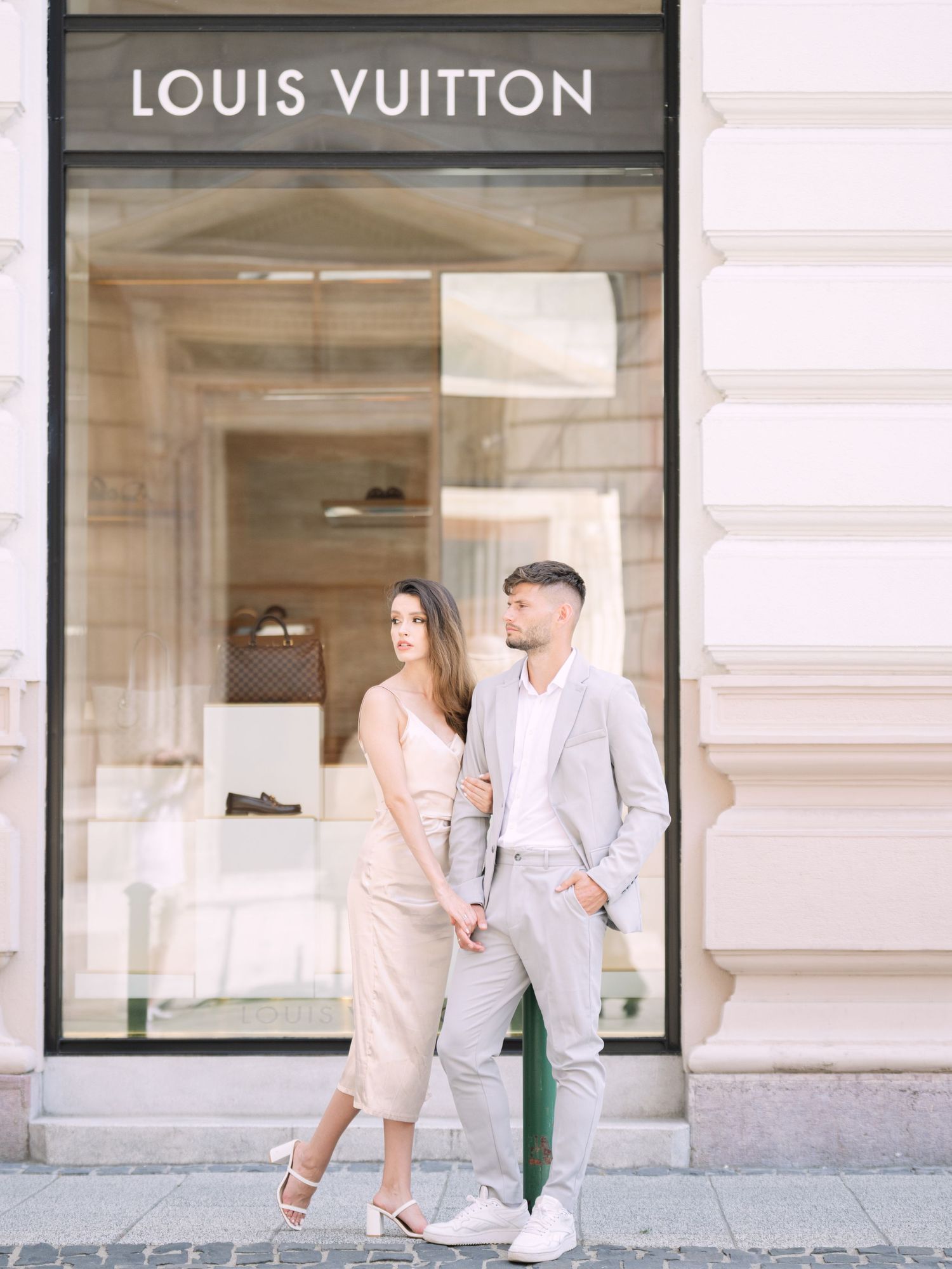 Dynamic couple posing stylishly on Andrássy Street in Budapest near the Louis Vuitton boutique during a chic portrait shoot by Hang Pham Pho