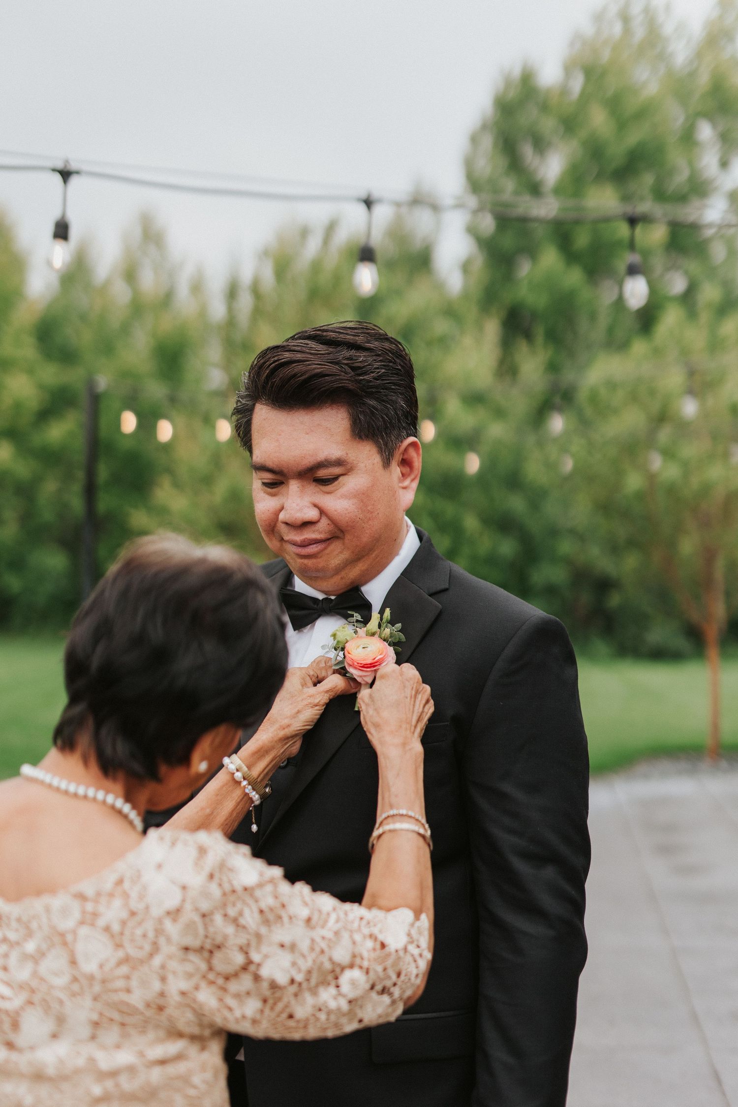 A tender moment captured between two people in formal attire during an outdoor wedding celebration.