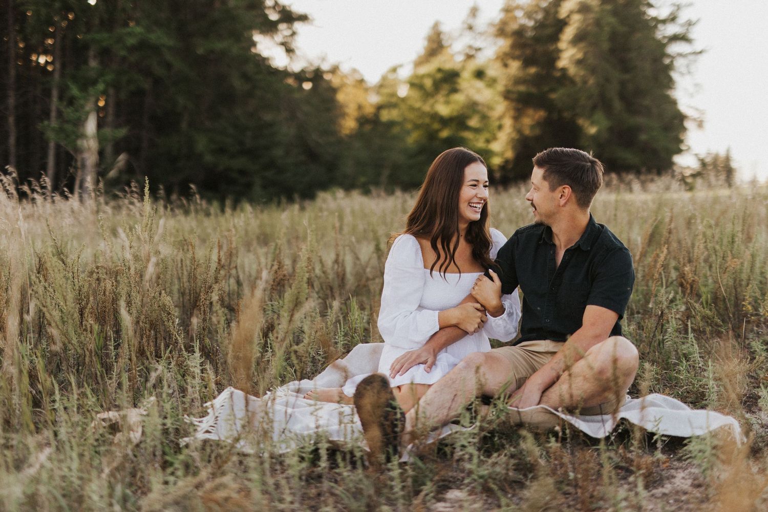 Romantic couple poses in golden wheat field during sunset photoshoot.