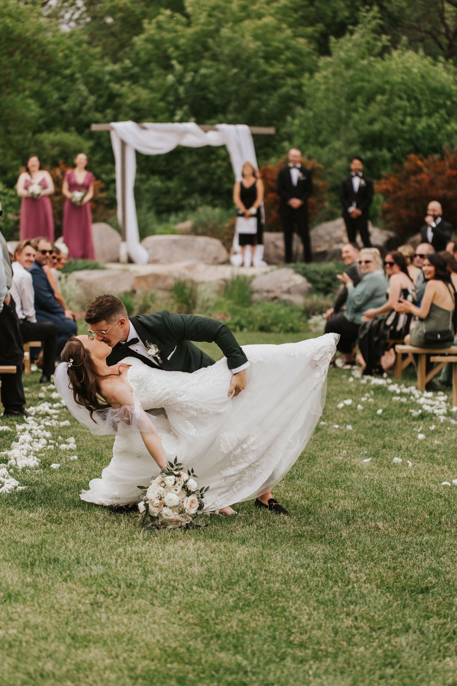 Wedding guests enjoying a playful moment on the grass-covered lawn.