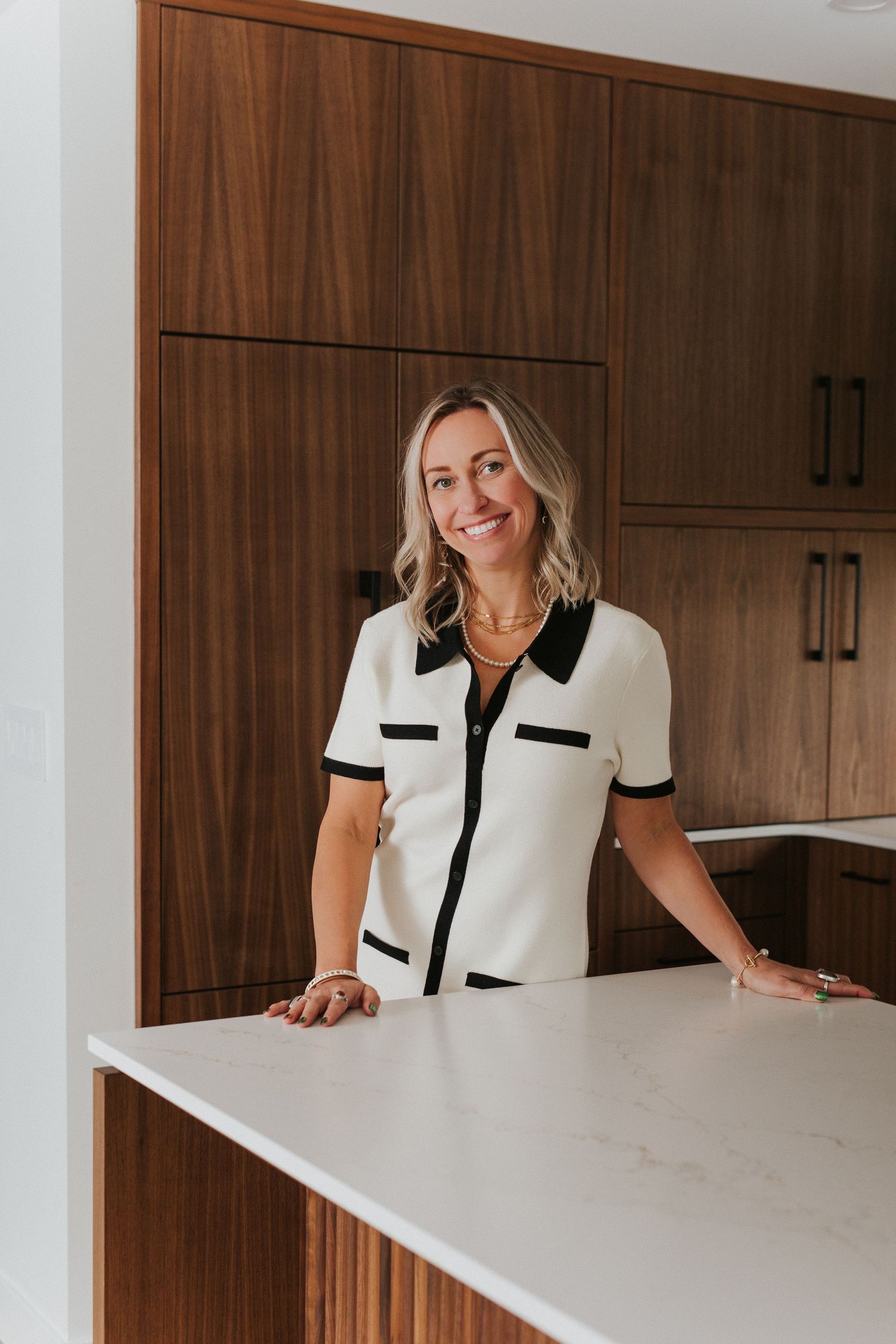 White desk setting with minimalist decor and wooden cabinets in background.