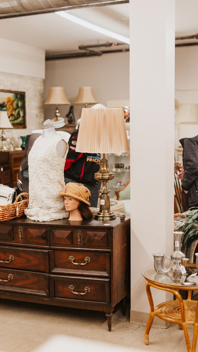 Vintage wooden dresser with lamps and decorative items arranged on top in a room setting.