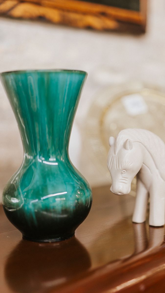Emerald green glass vase with fluted design displayed on wooden surface.