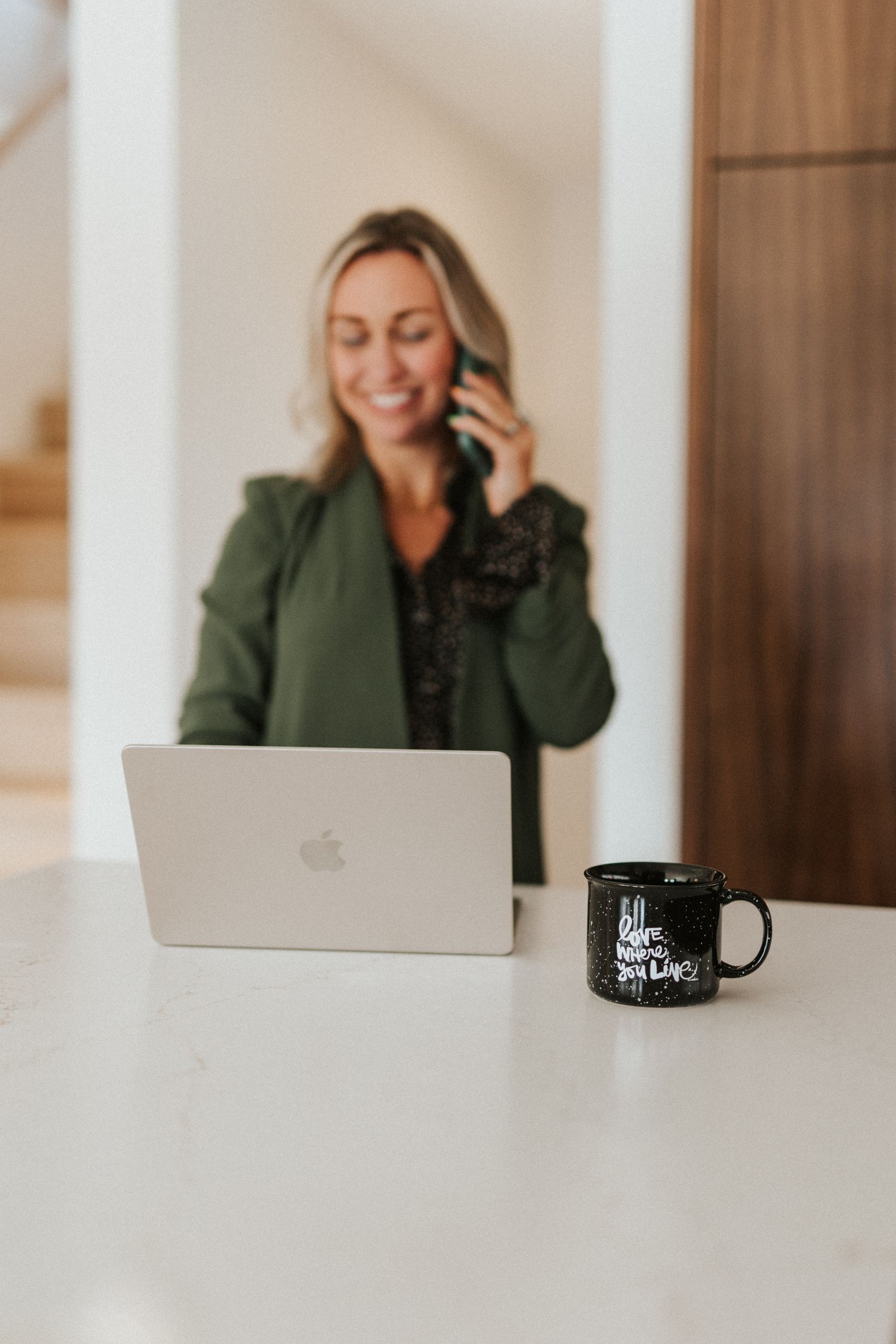 Modern office workspace with laptop and coffee mug on white desk.