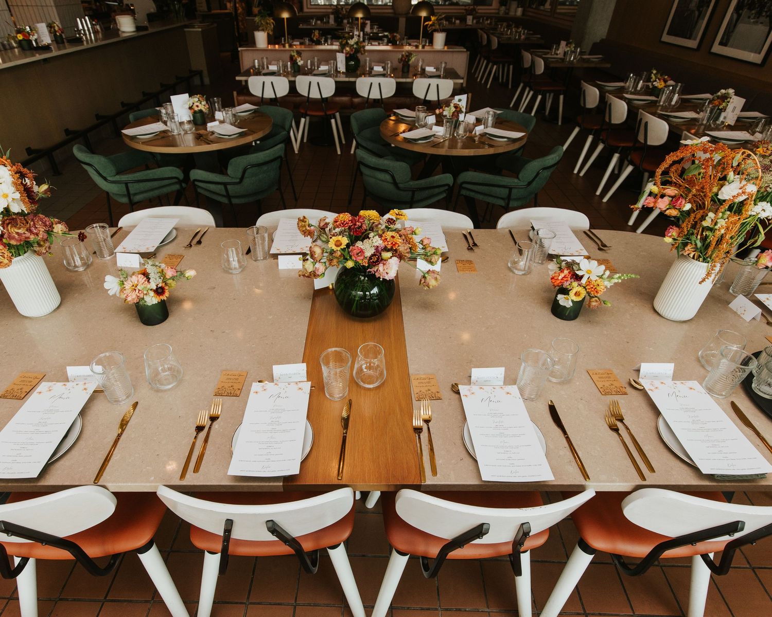 Elegant wedding reception table settings with place cards and neutral decor.