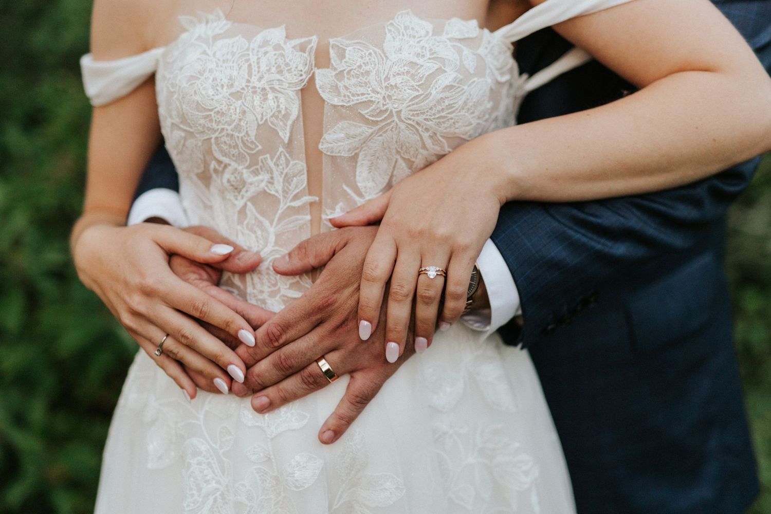 Close-up details of a delicate white lace wedding dress bodice with intricate floral patterns.