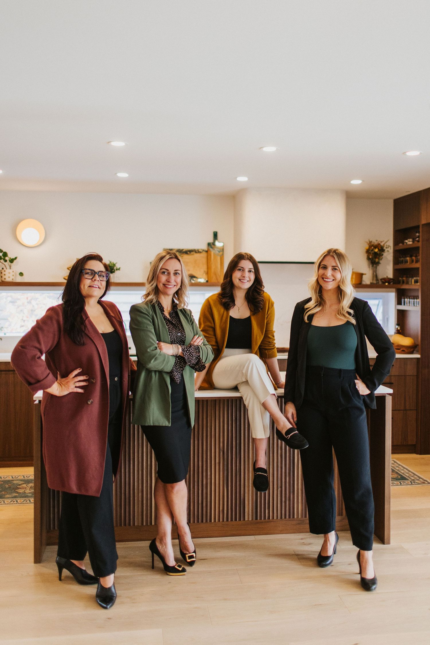 Group posing together in modern office space with wood paneled walls.