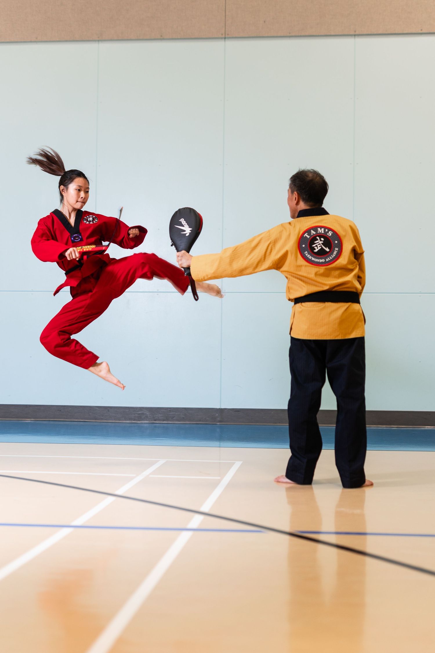Dynamic sequence of martial arts kicks being performed in a training studio.