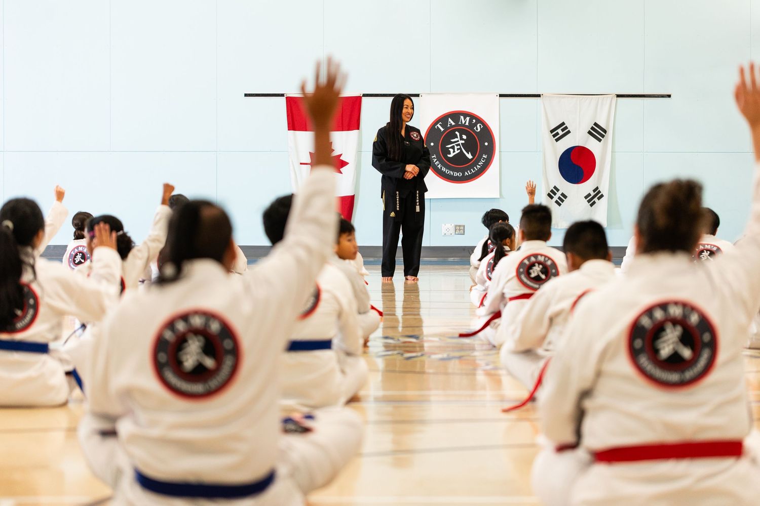 Martial arts practitioners training in a bright studio with red and white uniforms.