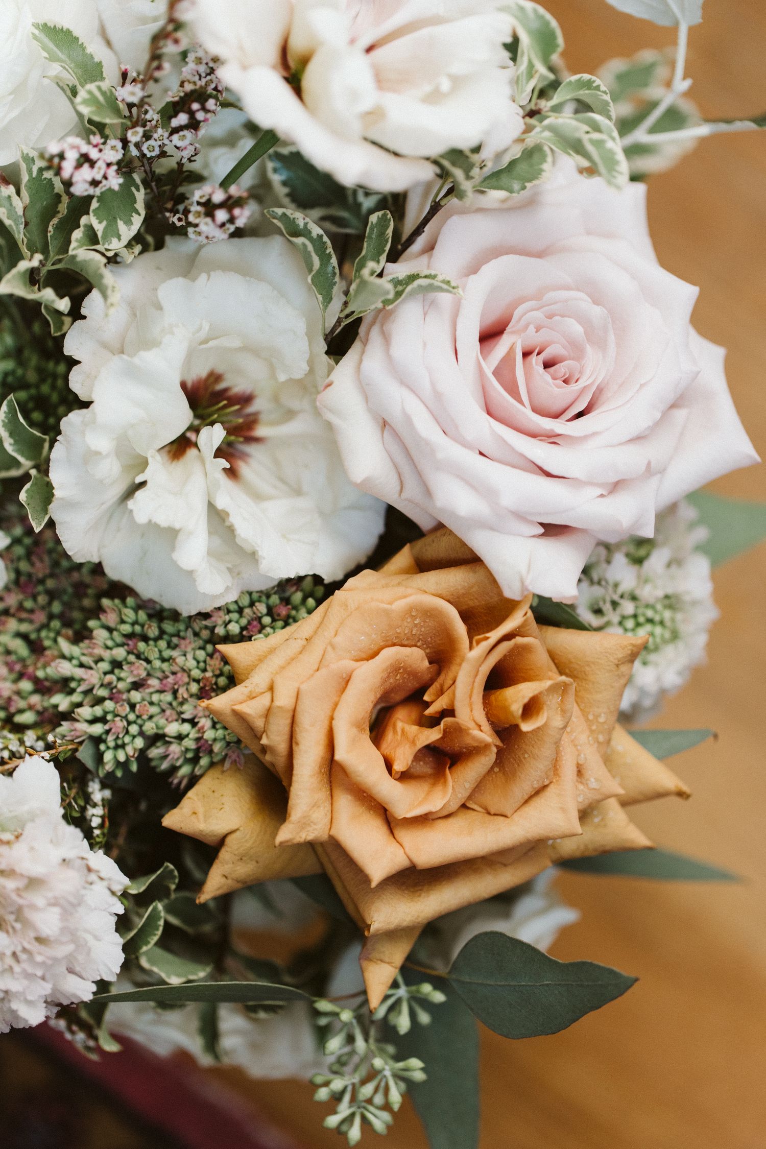 Romantic wedding bouquet with blush pink roses, white flowers, and eucalyptus greenery.