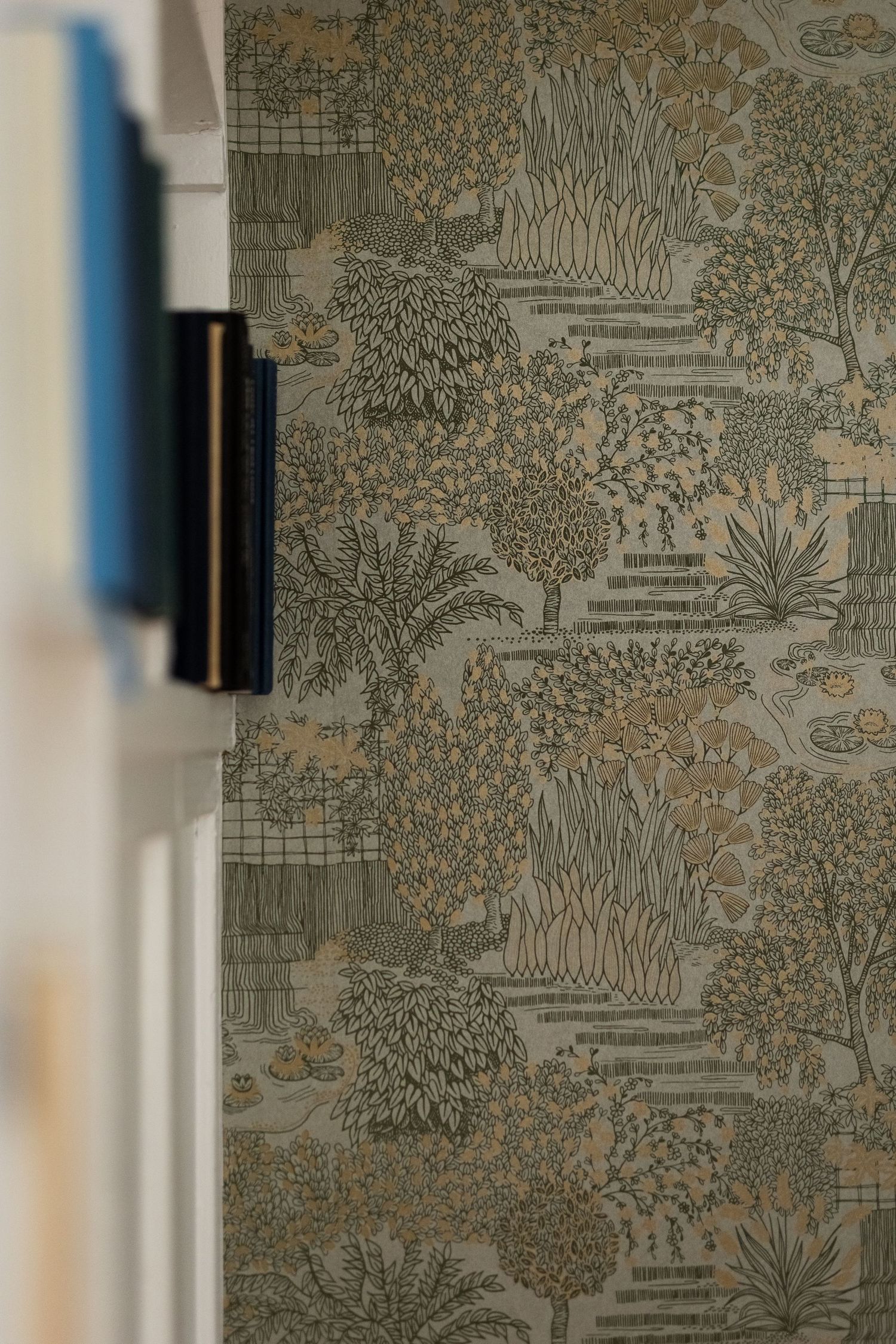 Decorative wallpaper featuring botanical garden scene in muted tones.