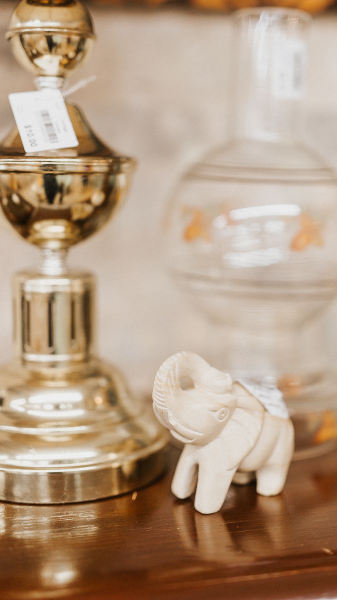 Small decorative white elephant figurines displayed next to glass candlesticks.