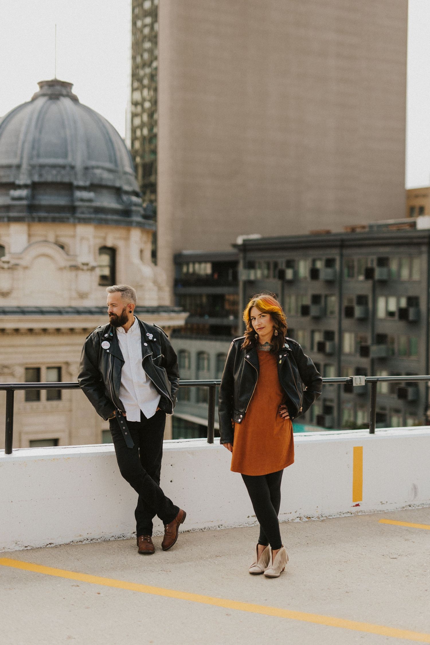 Rooftop photoshoot with couple against urban backdrop of domed buildings.