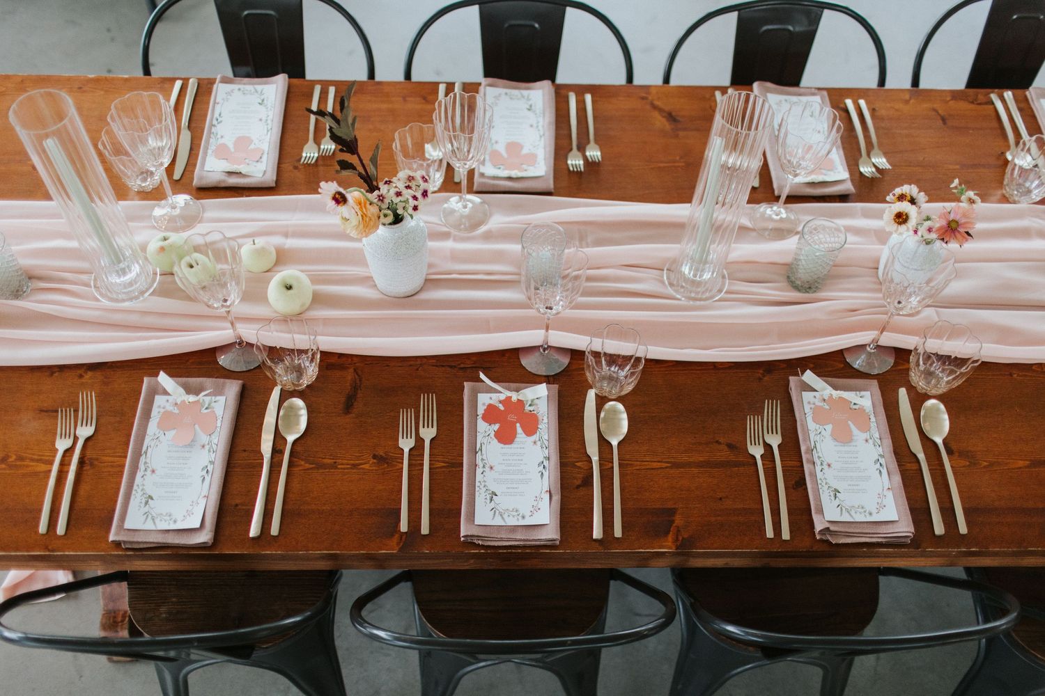 A formal dining table setting with black chairs and white place settings arranged in a row.