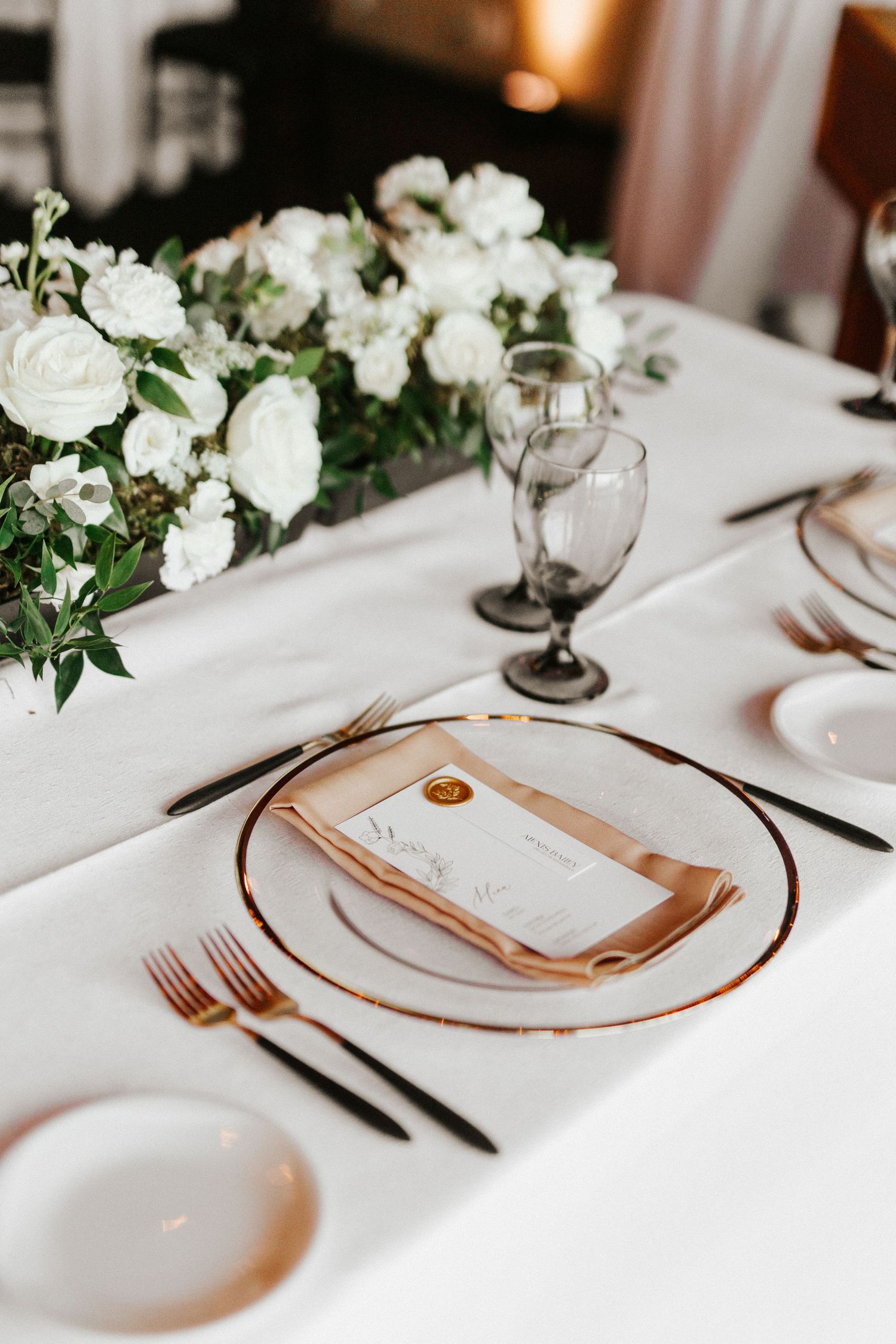 Winnipeg Wedding Photography. Elegant white and gold place setting with white floral centerpiece at wedding reception.