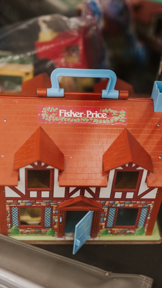 Vintage Fisher-Price toy building with orange brick design and blue accents.