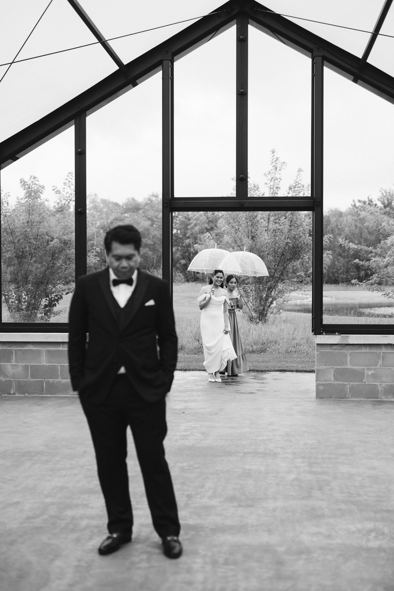 A series of five black and white photos showing people in formal attire standing in a modern architectural space.