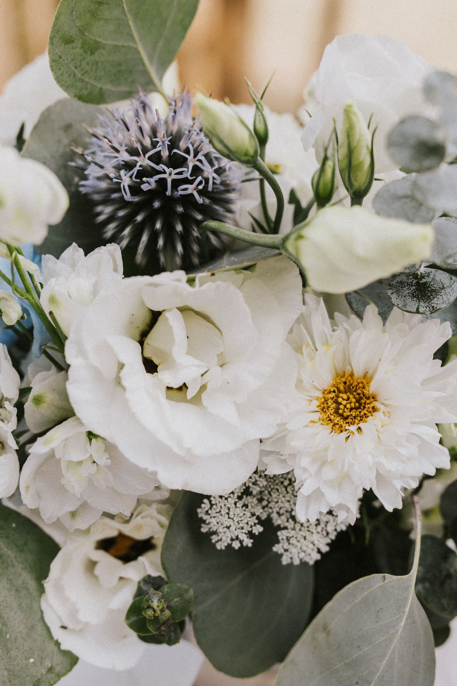 Close up of delicate white flowers and greenery in an elegant wedding bouquet arrangement.