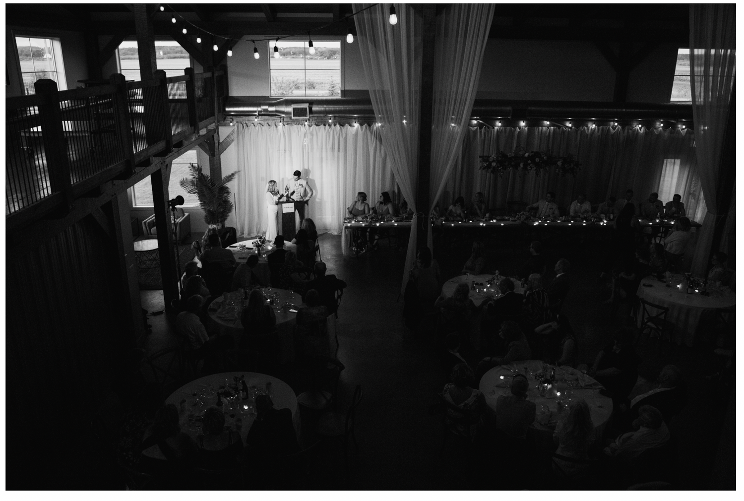 Dark silhouette of wedding reception venue with string lights creating ambient atmosphere.