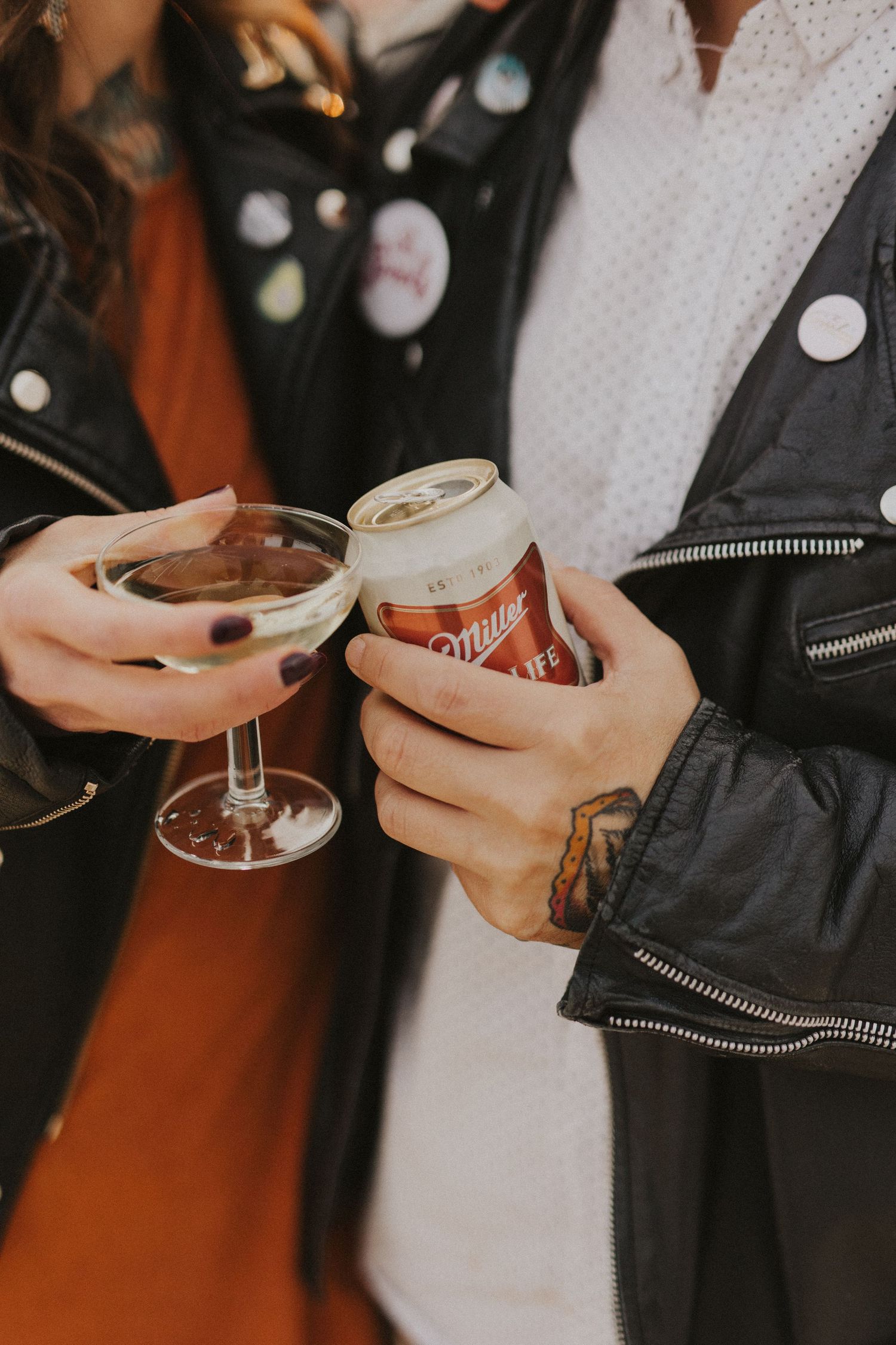 Hands holding champagne glasses in celebratory toast against dark background.