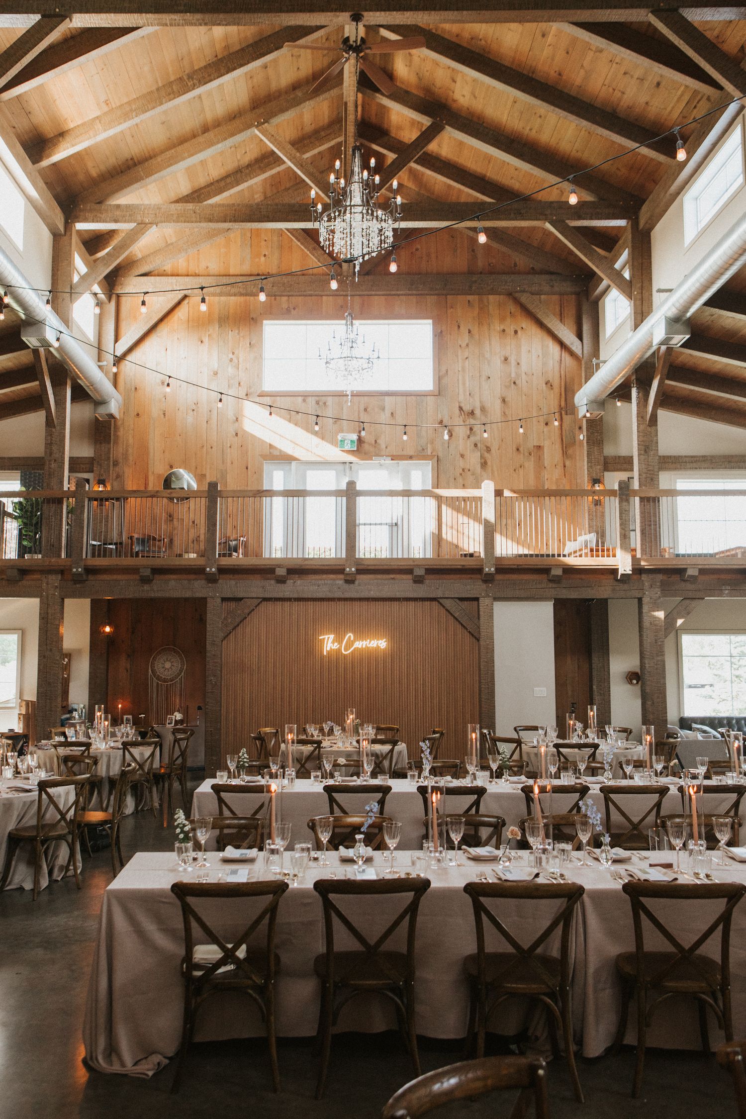 Rustic barn reception venue with exposed beams and elegant table settings.