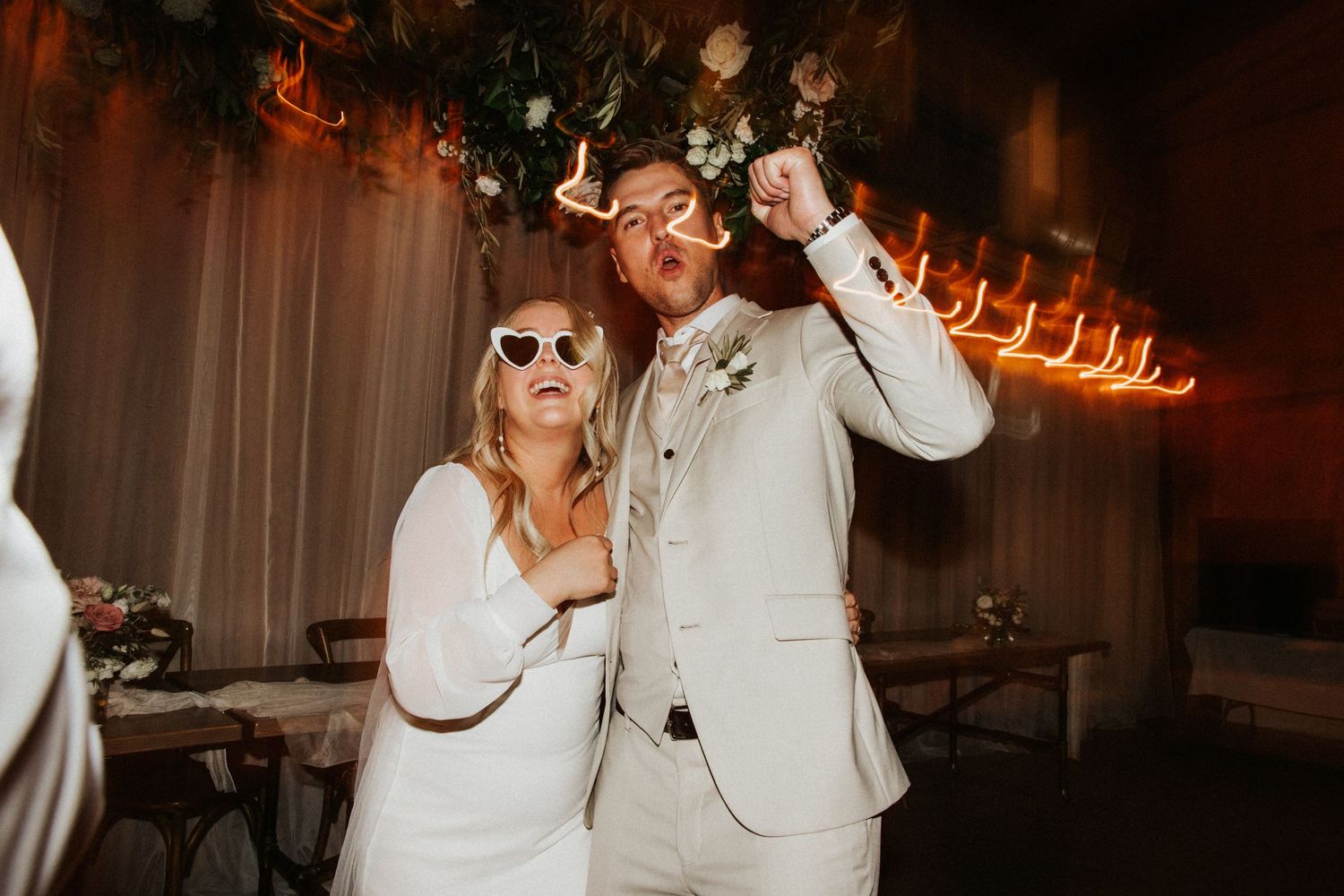 Wedding reception dance party with dark ambient lighting and festive atmosphere.