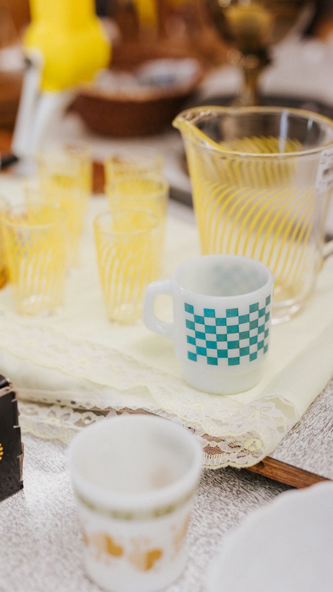 Vintage turquoise and white striped paper cups lined up in a row on a textured surface.