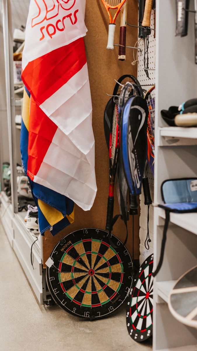 Red and white flags displayed above dartboards in a recreational room setting.