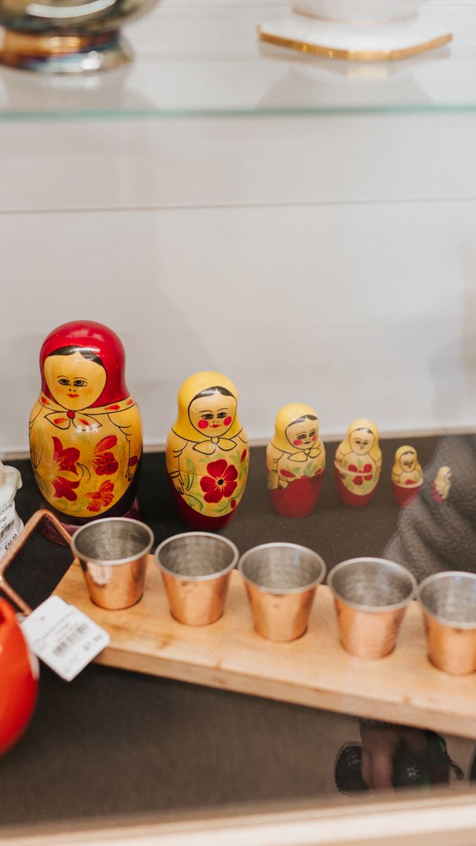 Traditional Russian matryoshka nesting dolls displayed alongside small metal containers.
