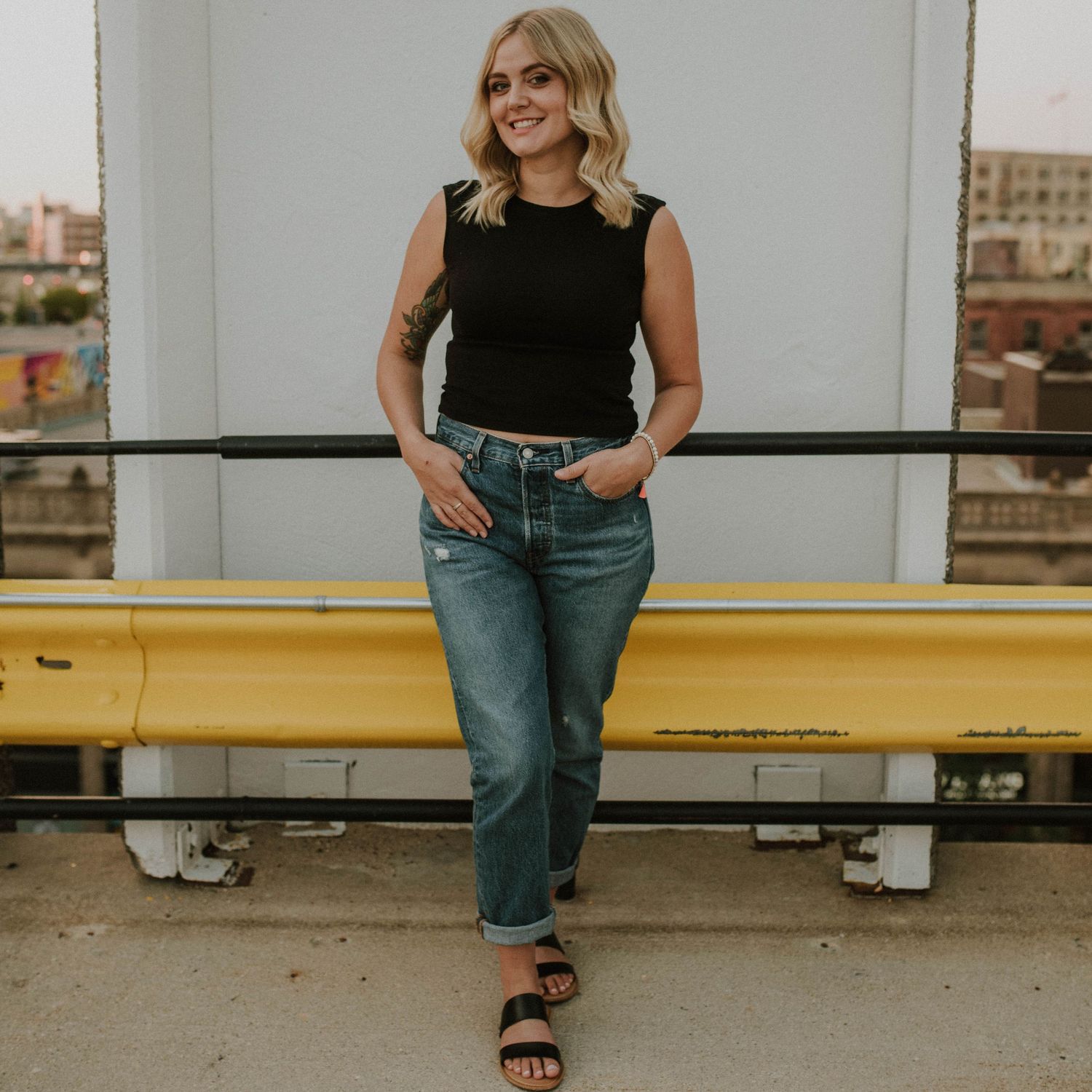 Fashion photography series showing casual outfit against industrial backdrop.