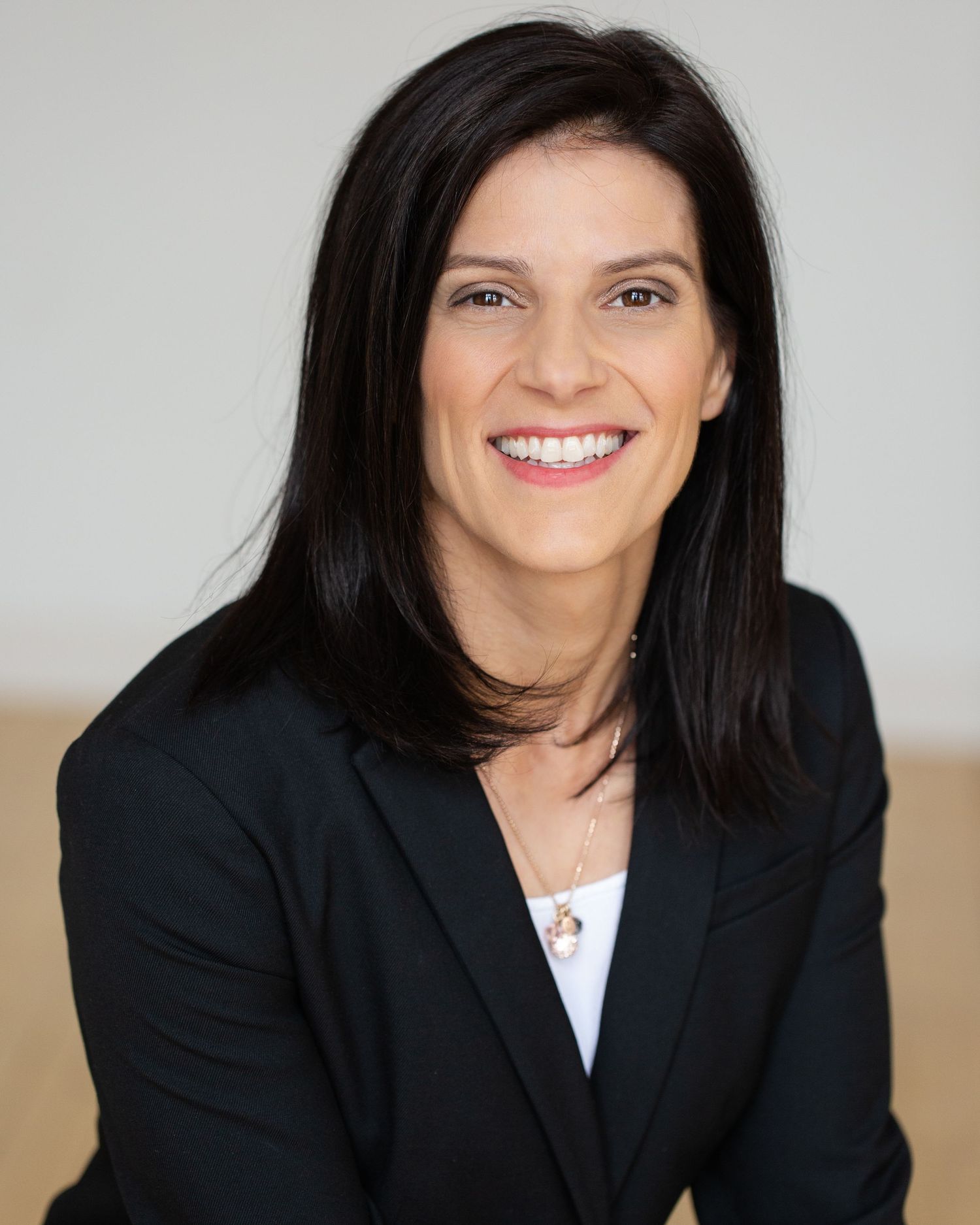 Professional business portraits showing a businesswoman in a black blazer.