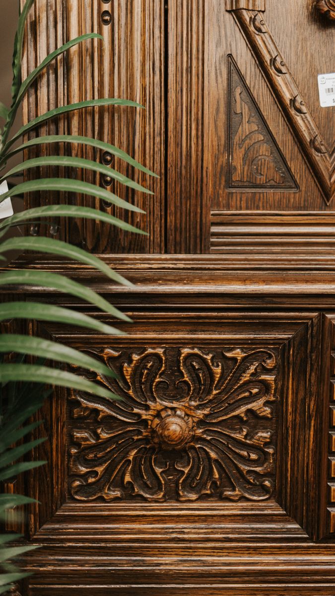 Ornate carved wooden panel with floral sunburst design and dark stained finish.
