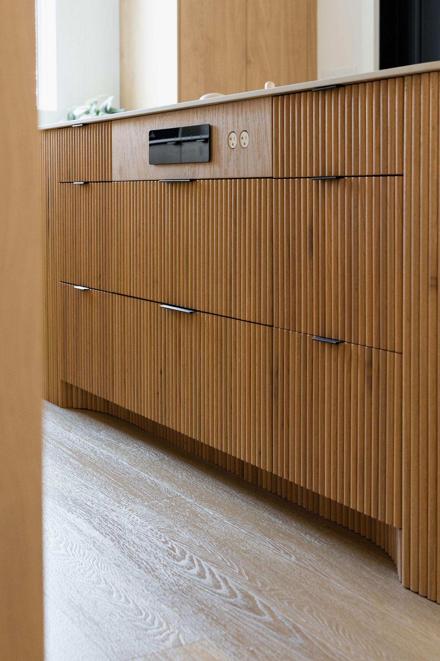 Modern wooden cabinet with vertical slats and sleek hardware.