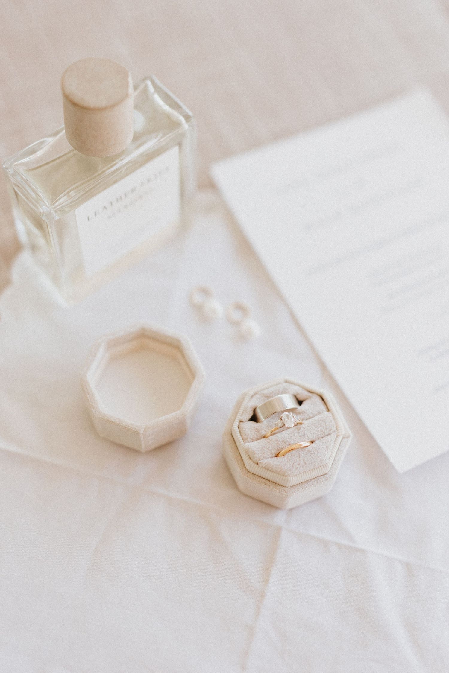 Elegant wedding rings displayed on white surface with minimalist styling.