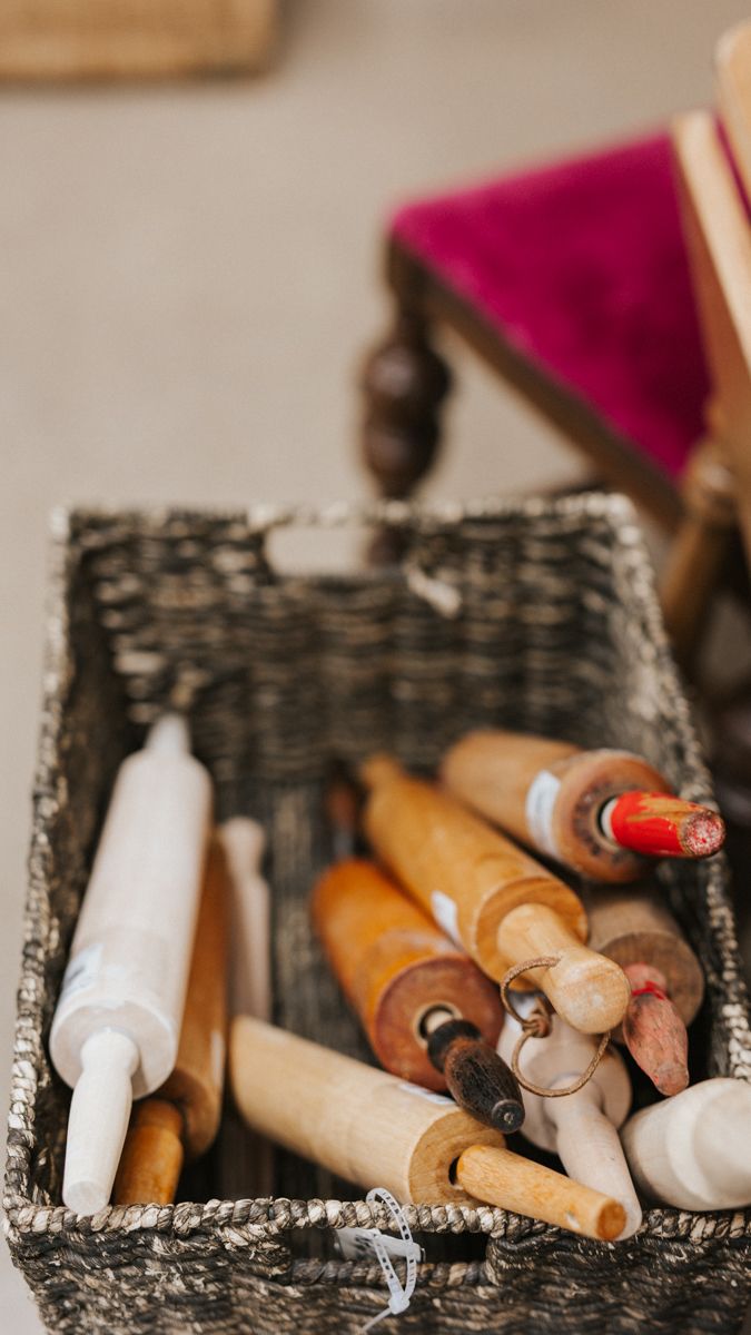 Collection of vintage wooden and ceramic paintbrushes arranged in a decorative box.