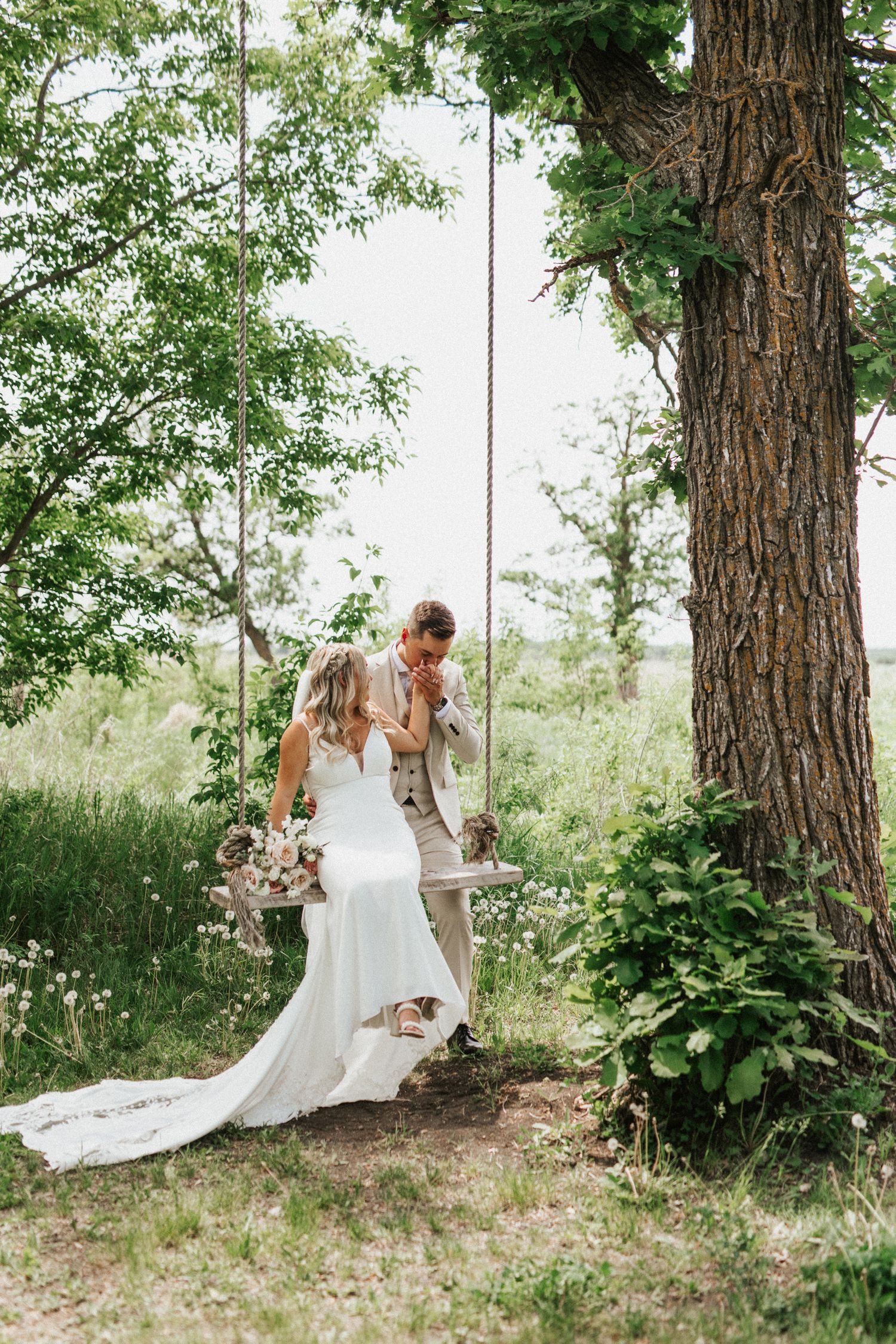 A romantic tree swing photo session with flowing white wedding dress in a natural setting.